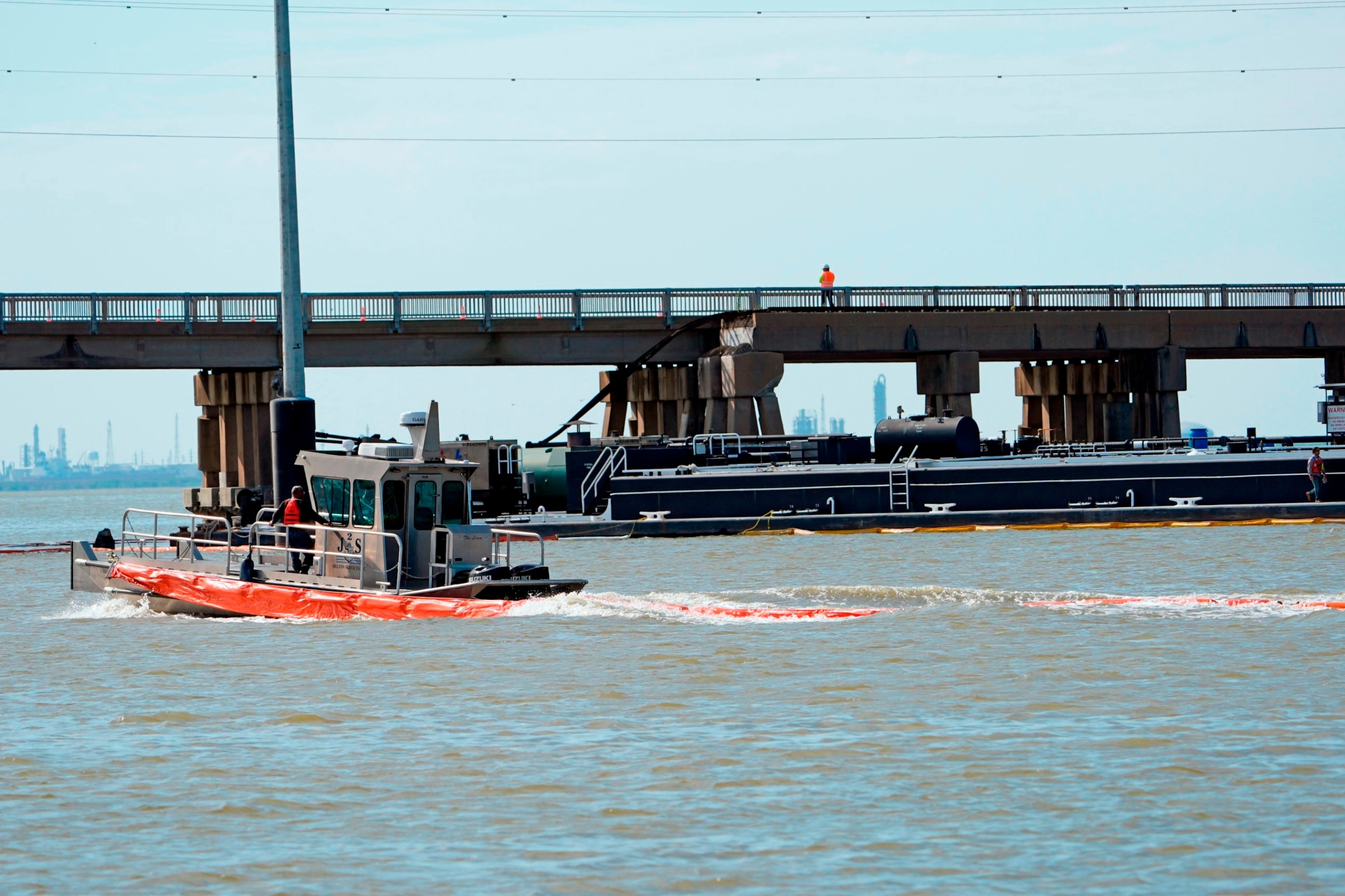 PHOTO: An spill boom is moved into position to contain a leak from a barge that crashed into the Pelican Island Bridge, May 15, 2024, in Galvestobn, Texas.
