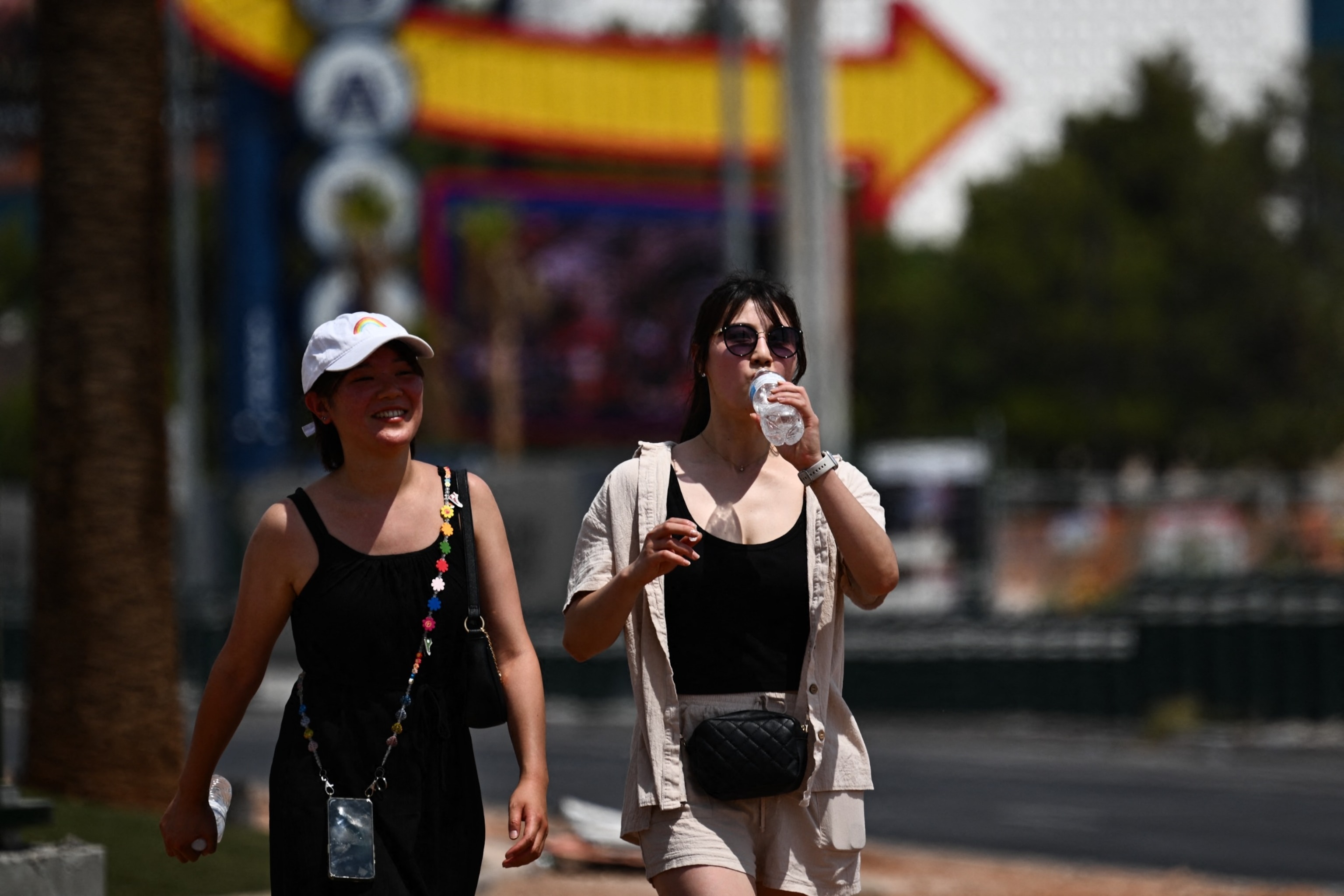 PHOTO: A person drinks a bottle of water while walking in the heat in Las Vegas, on July 30, 2023, as temperatures reach more than 100 degrees Fahrenheit (37.78C). 