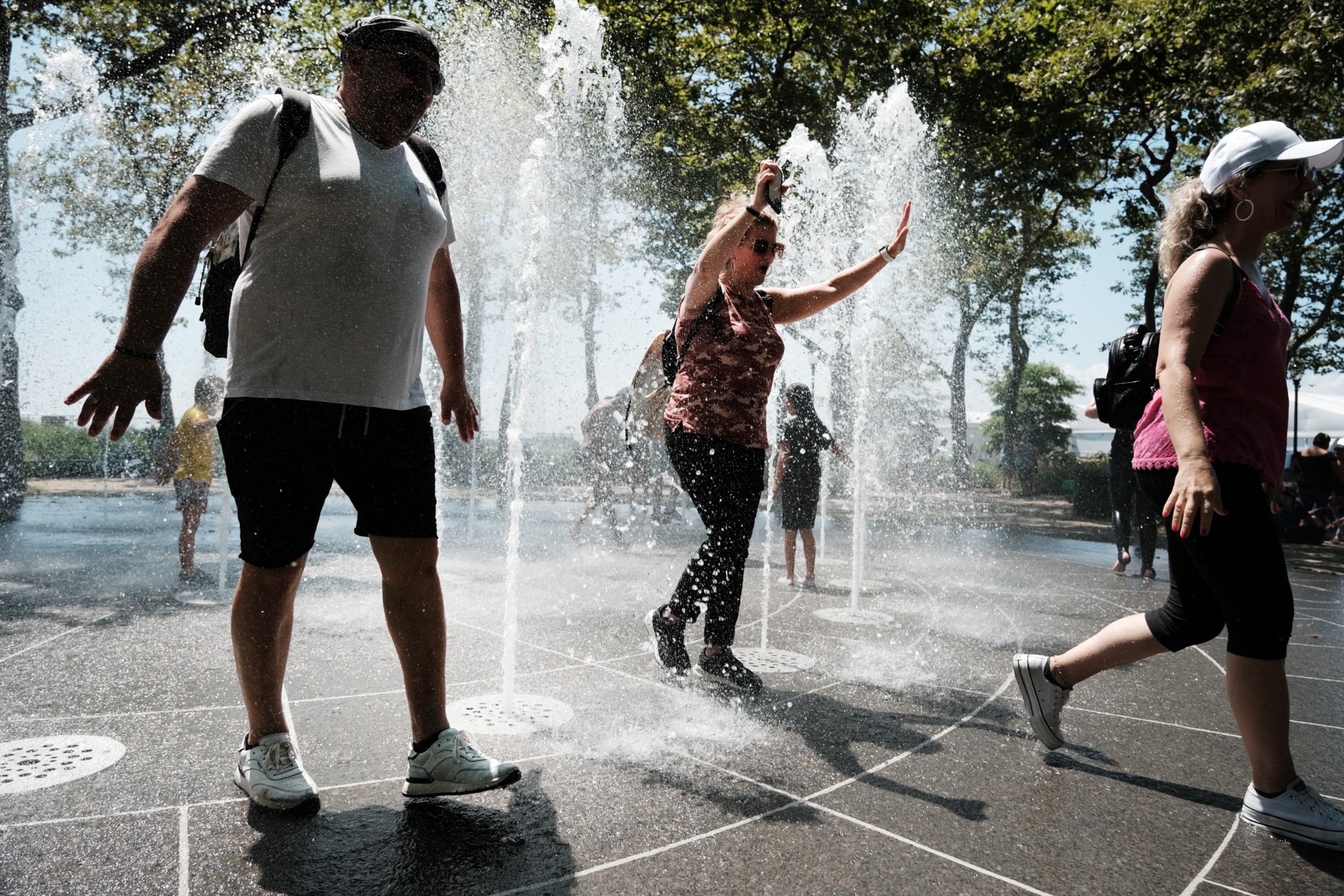 PHOTO: Children and adults cool off in a fountain in a lower Manhattan park on a hot afternoon in the city on July 06, 2023 in New York City.