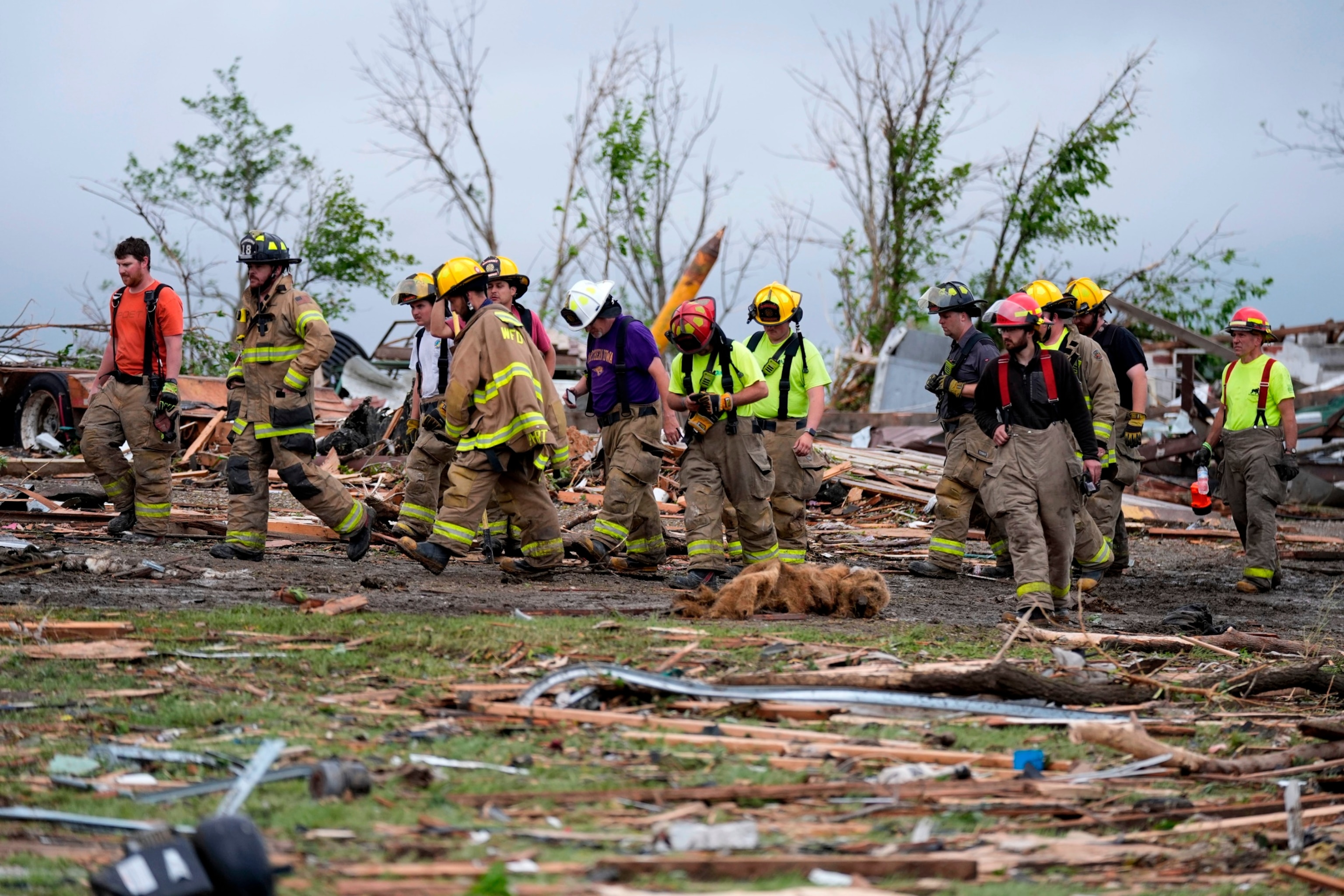 Firefighters walks among tornado-damaged homes, Tuesday, May 21, 2024, in Greenfield, Iowa. (AP Photo/Charlie Neibergall)