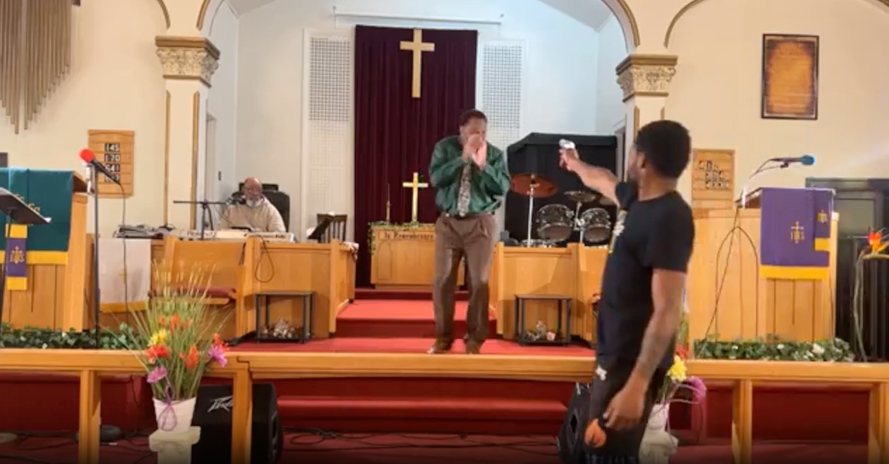 PHOTO: A man pulls a gun during a sermon at Jesus' Dwelling Place Church in North Braddock, Pa., in a screengrab from a video taken on Sunday, May 5, 2024.