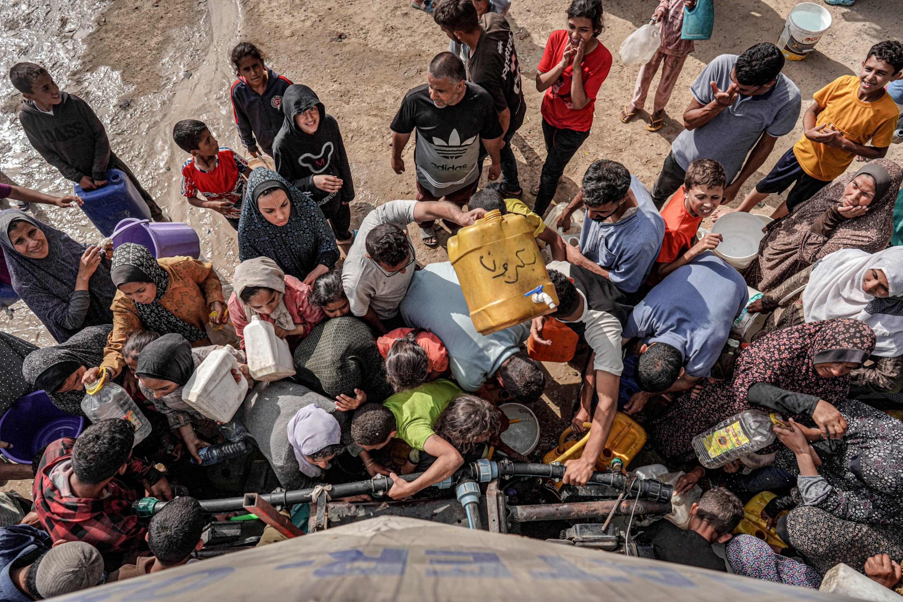 PHOTO: People gather with jerrycans and other containers to collect water from a tanker cistern in Deir el-Balah in the central Gaza Strip on Apr. 30, 2024.