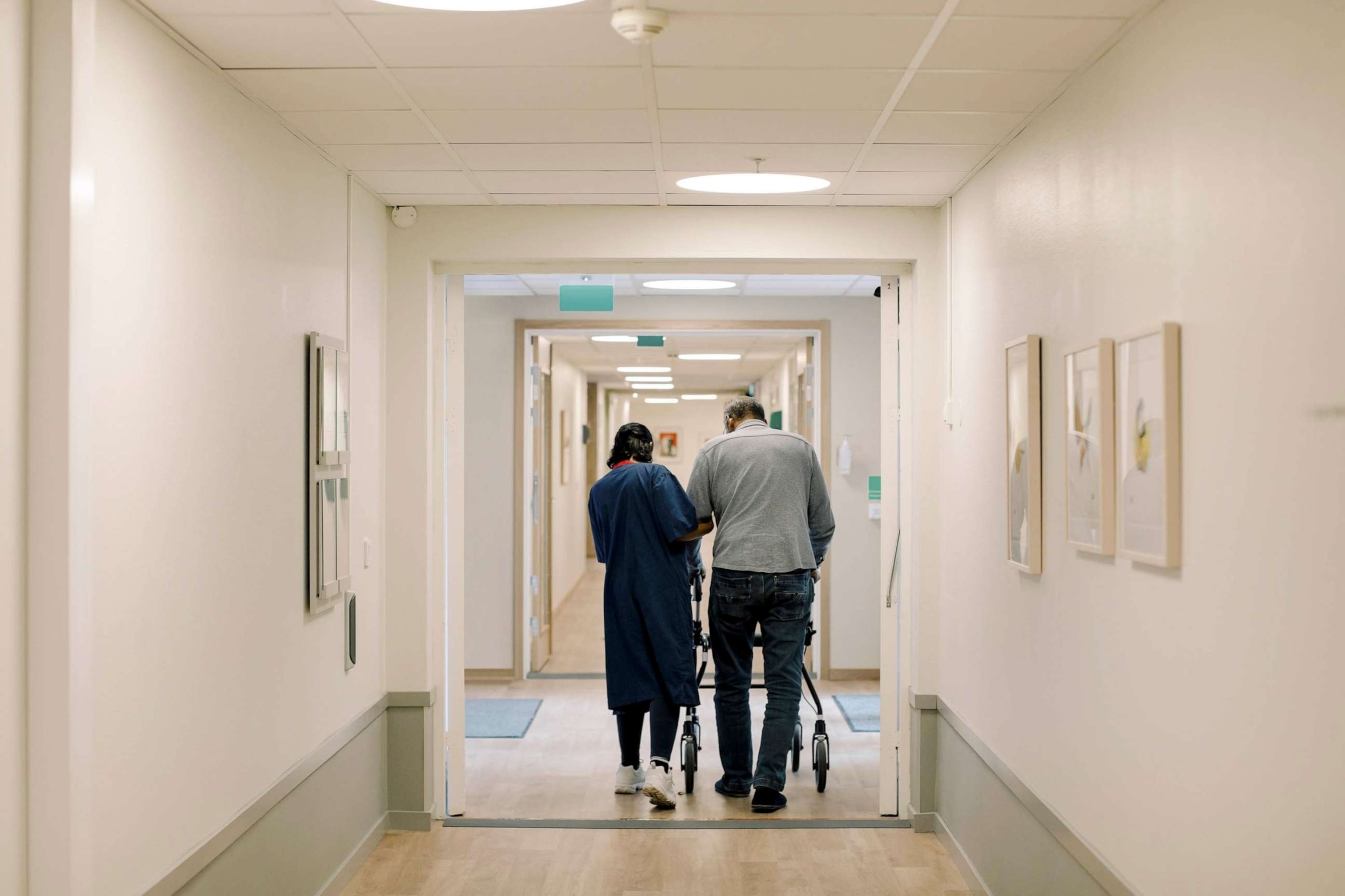 STOCK PHOTO: In this undated stock photo, an elderly man is being walked down a nursing home hall by a nurse.