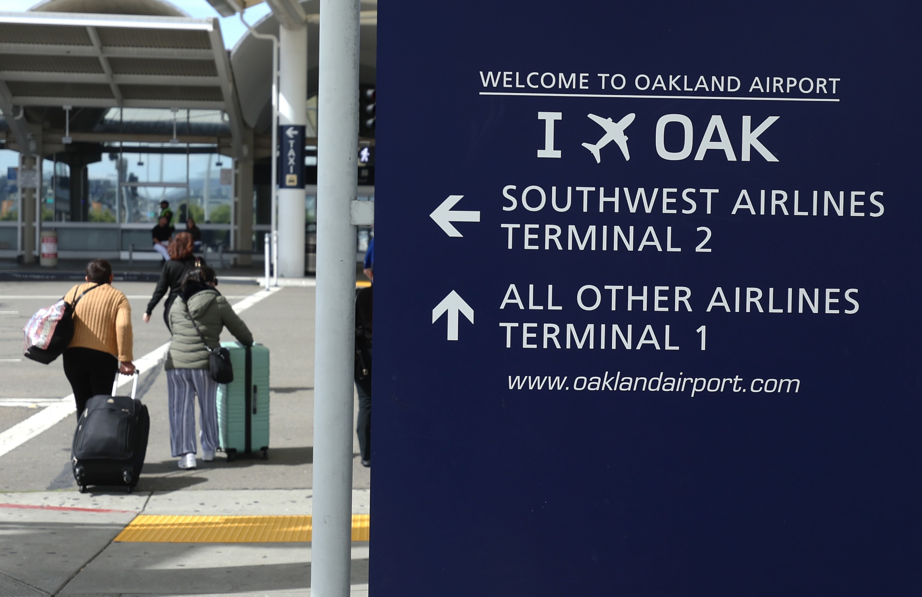 PHOTO: Travelers walk towards Terminal 1 at Oakland International Airport in Oakland, CA, April 12, 2024.
