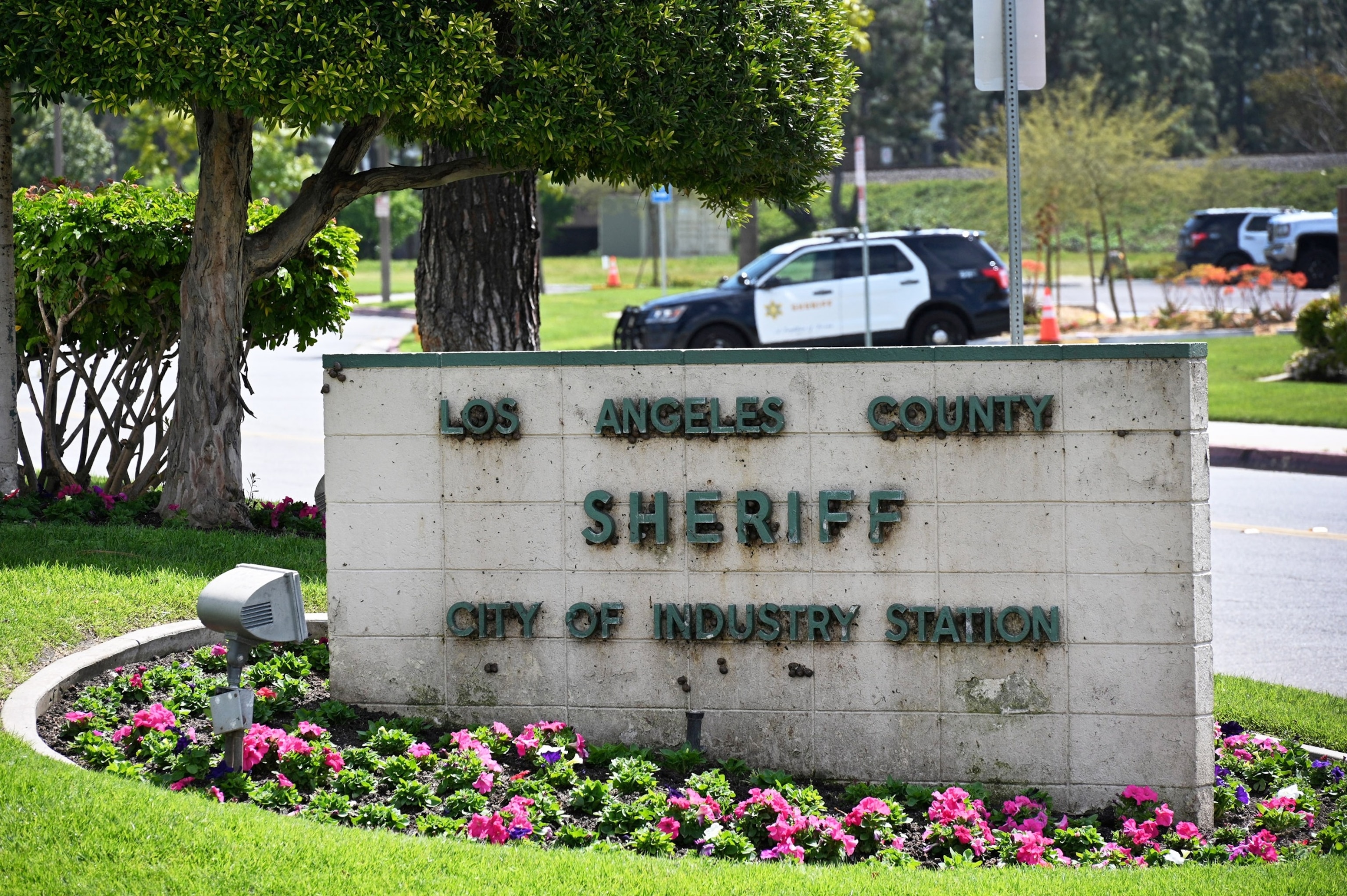 PHOTO: A sheriff's car is seen behind a sign at the entrance of the Los Angeles County Sheriff's Station, in City of Industry, Calif., on March 25, 2024. 