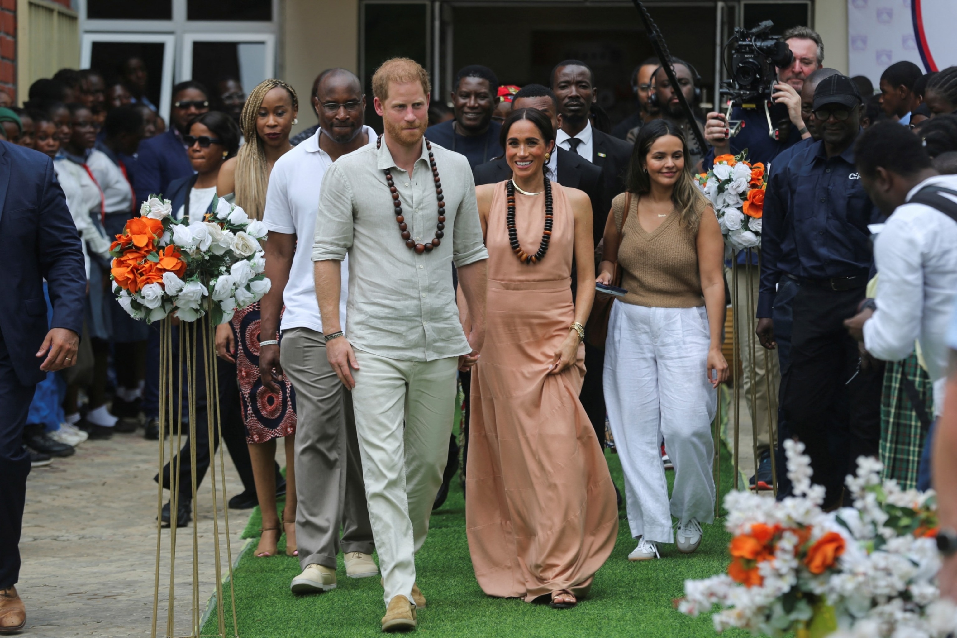 PHOTO: Prince Harry, Duke of Sussex and his wife Meghan, Duchess of Sussex, walk out after meeting the students at the Lightway Academy in Abuja, Nigeria, May 10, 2024.