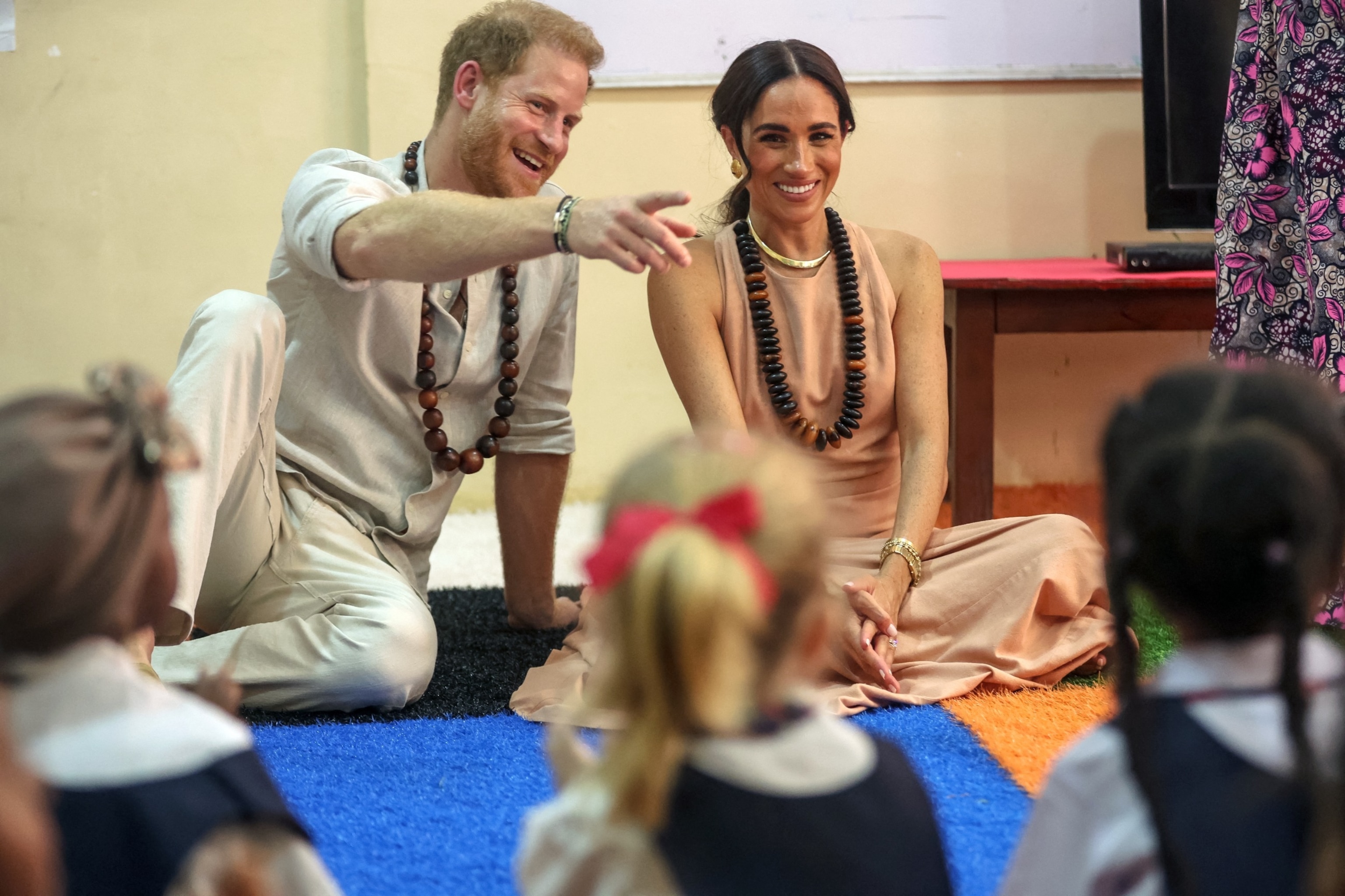 PHOTO: Prince Harry, Duke of Sussex, and Meghan ,Duchess of Sussex, meet with children during their visit at the Lightway Academy in Abuja on May 10, 2024.