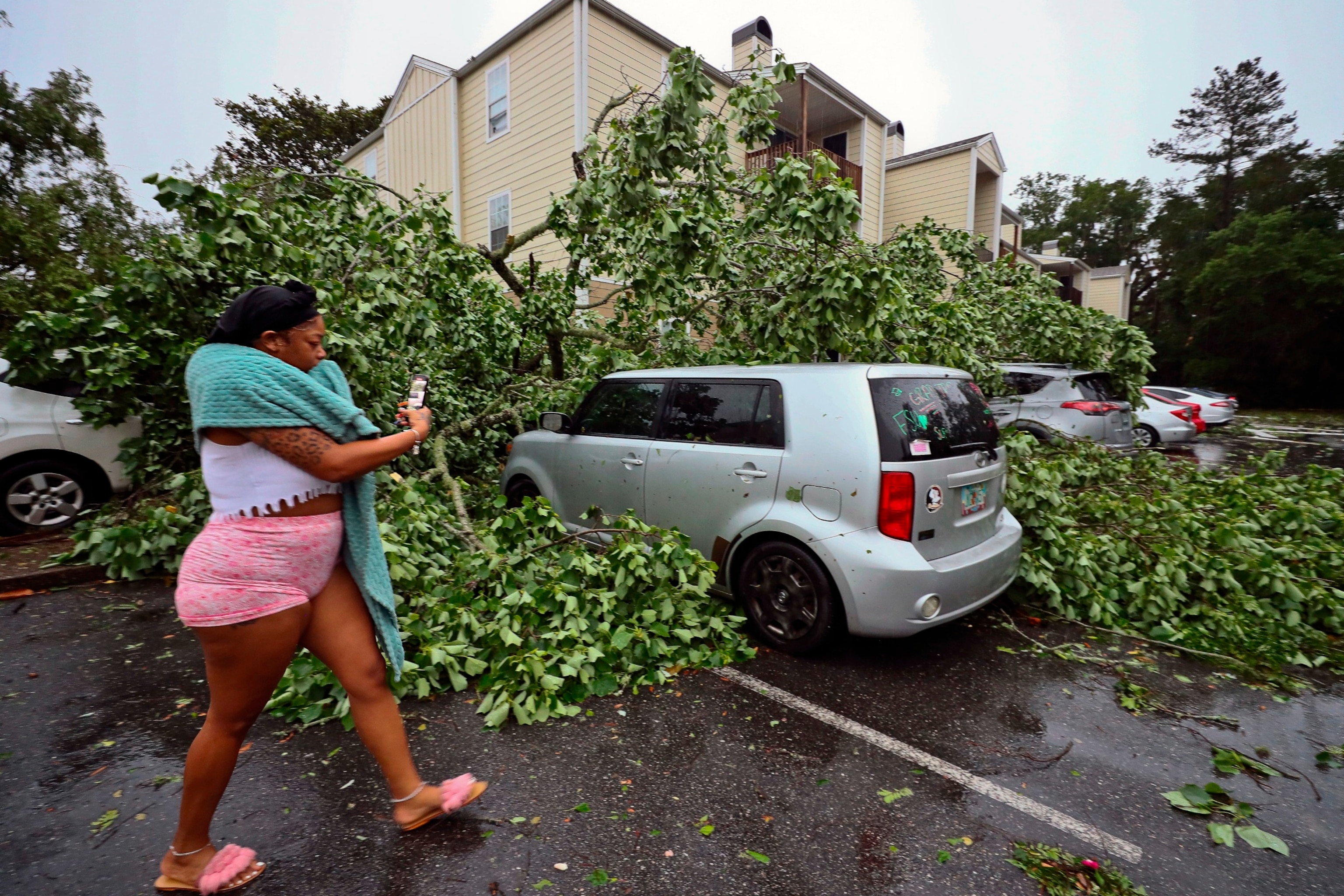 PHOTO: A resident records the damage to cars outside an apartment complex in Tallahassee, Fla., May 10, 2024.