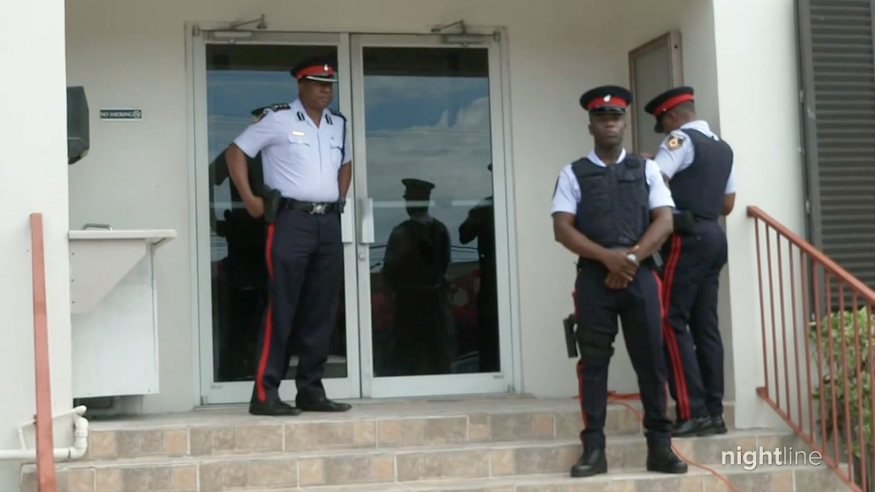 PHOTO: Turks and Caicos officers stand outside a police station.