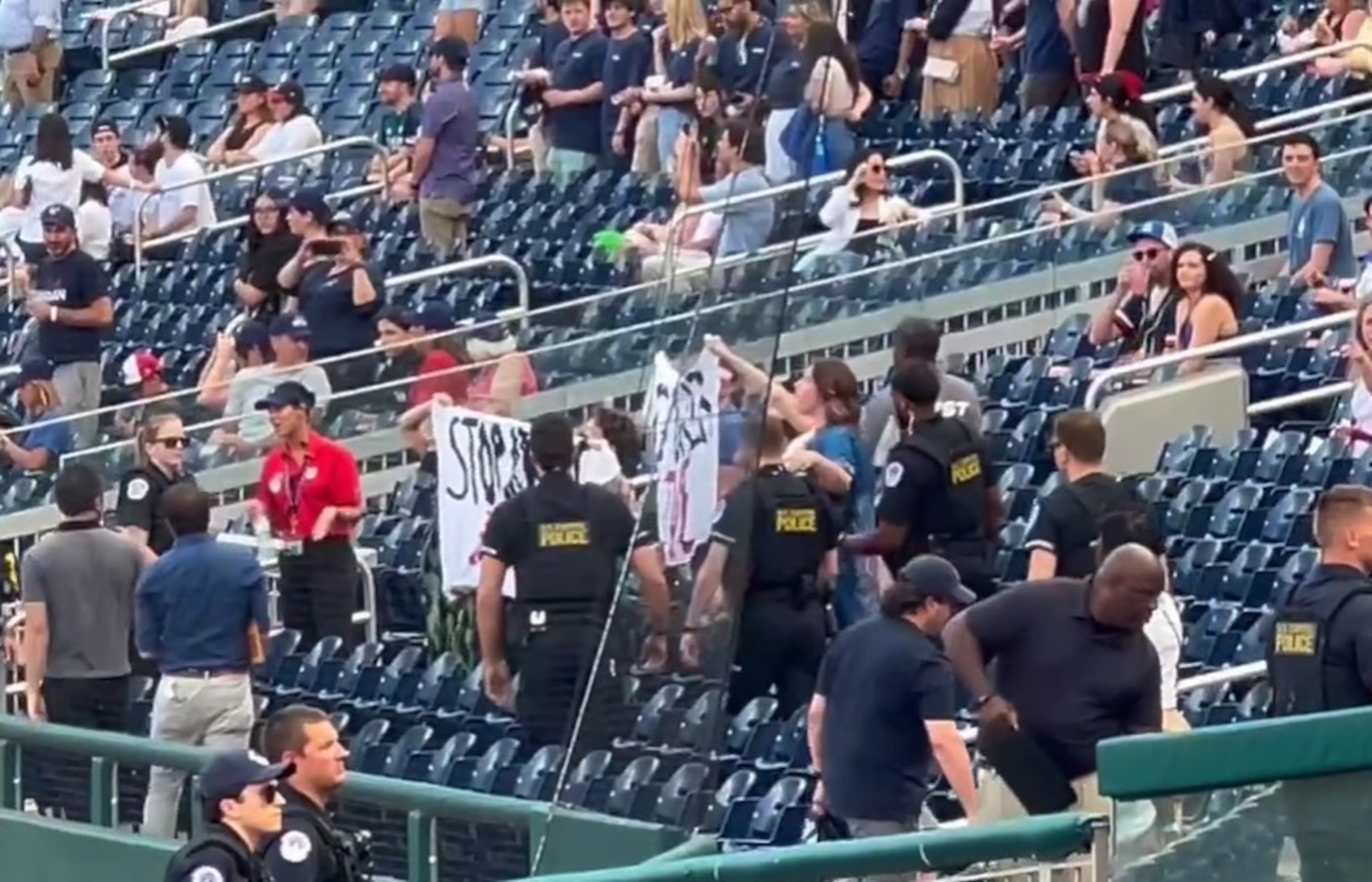 PHOTO: Anti-fossil fuel protesters hold up banners at the Congressional baseball game in Washington, D.C., on June 12, 2024.