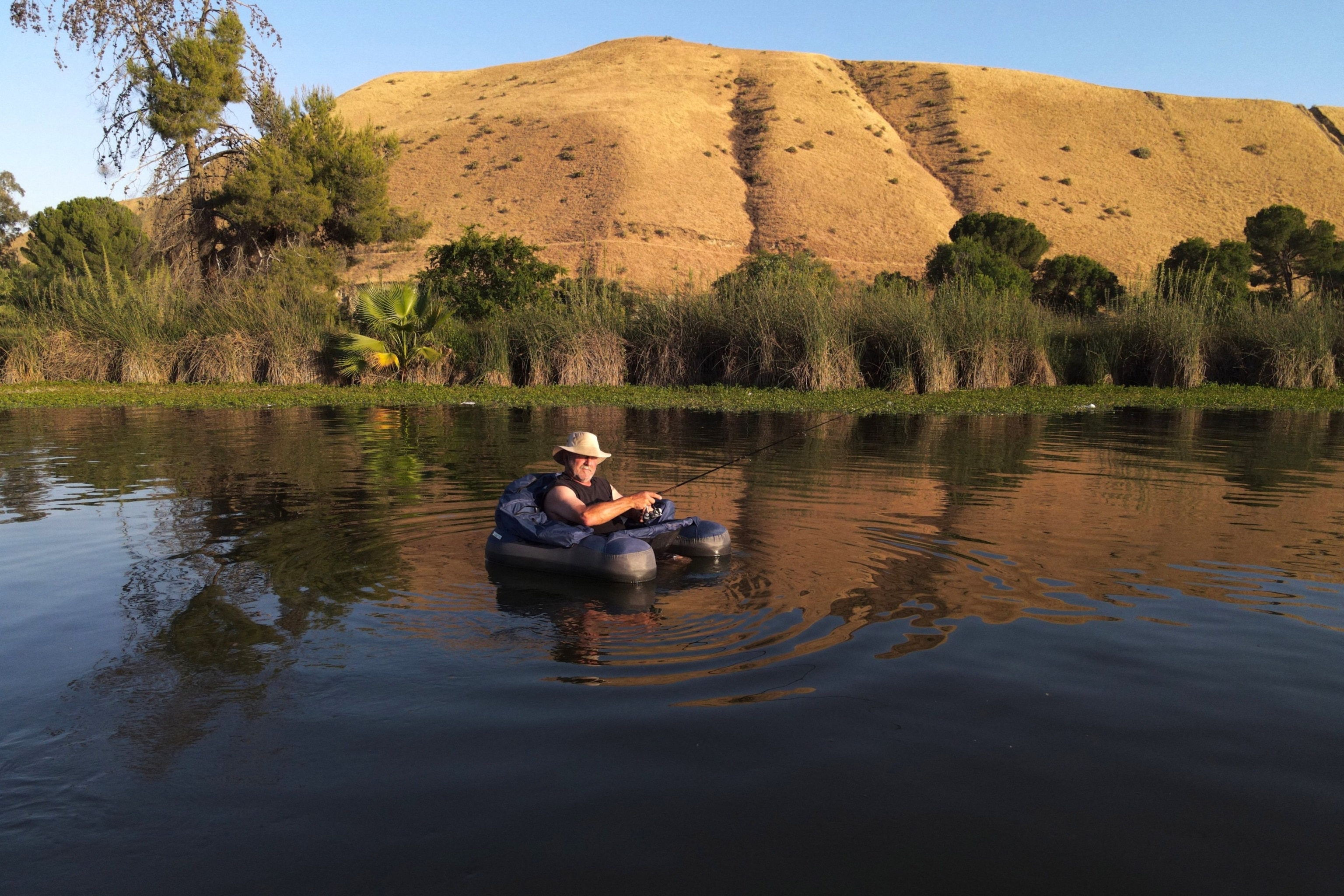 PHOTO: A fisherman finds relief from the over 100 degrees Fahrenheit temperature in the lake in Hart Memorial Park in Bakersfield, California, on June 5, 2024.