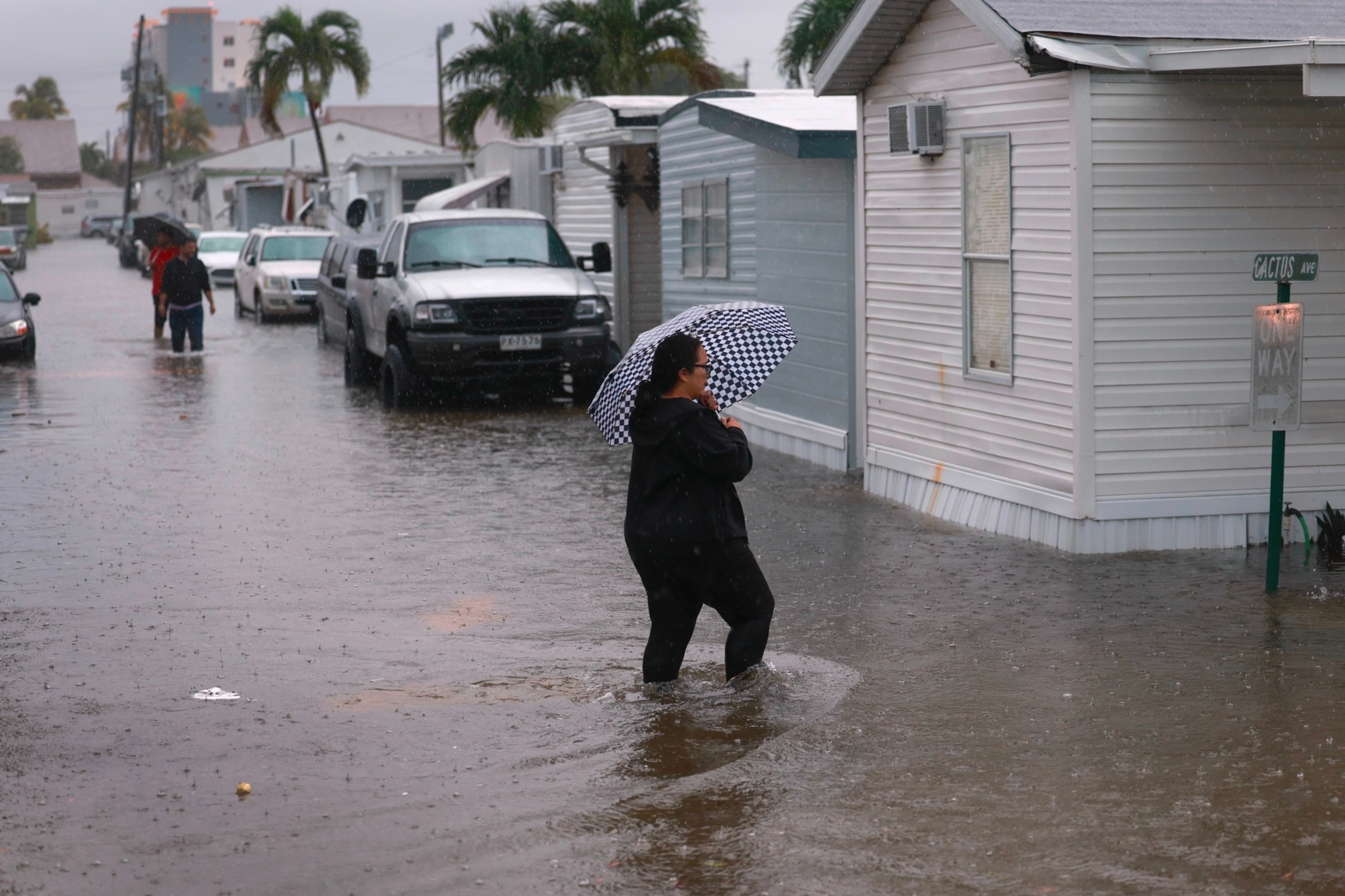 PHOTO: People walk through a flooded street in Hallandale Beach, FL, June 12, 2024, 