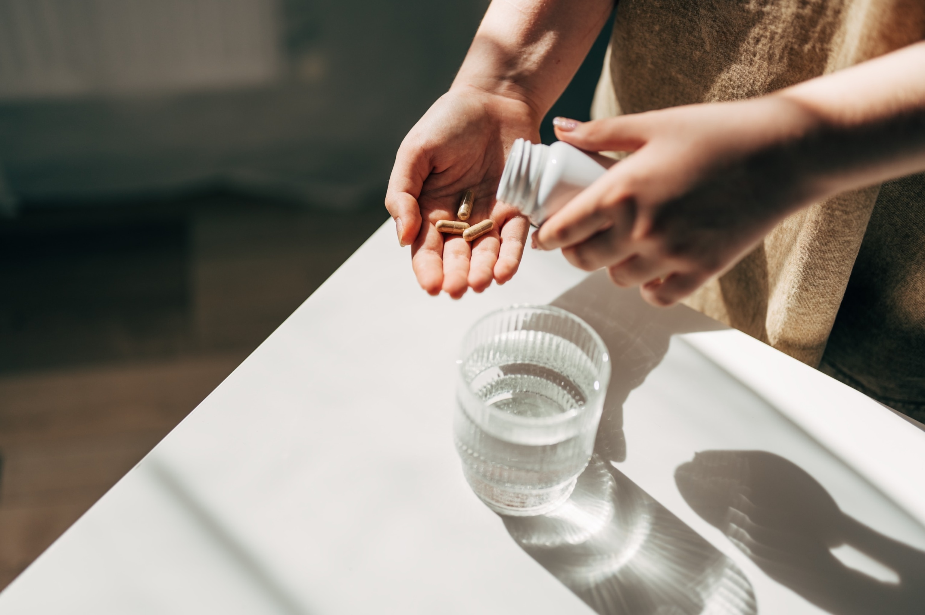 PHOTO: An undated stock photo shows a hand with pills and water glass.