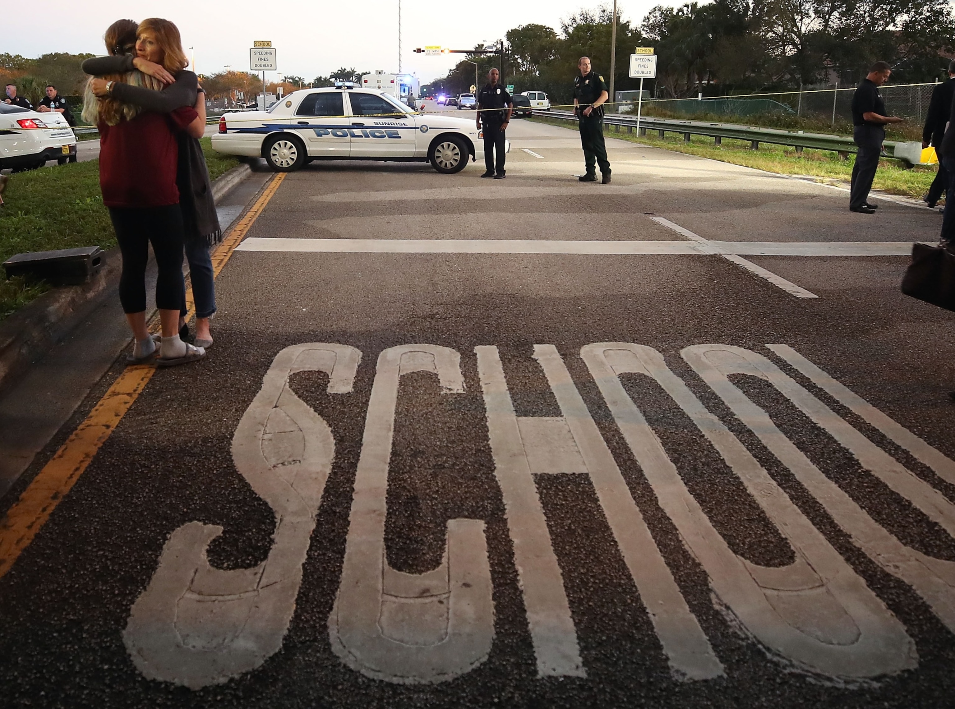 PHOTO: Kristi Gilroy (R), hugs a young woman at a police check point near the Marjory Stoneman Douglas High School where 17 people were killed by a gunman yesterday, Feb. 15, 2018, in Parkland, Fla.