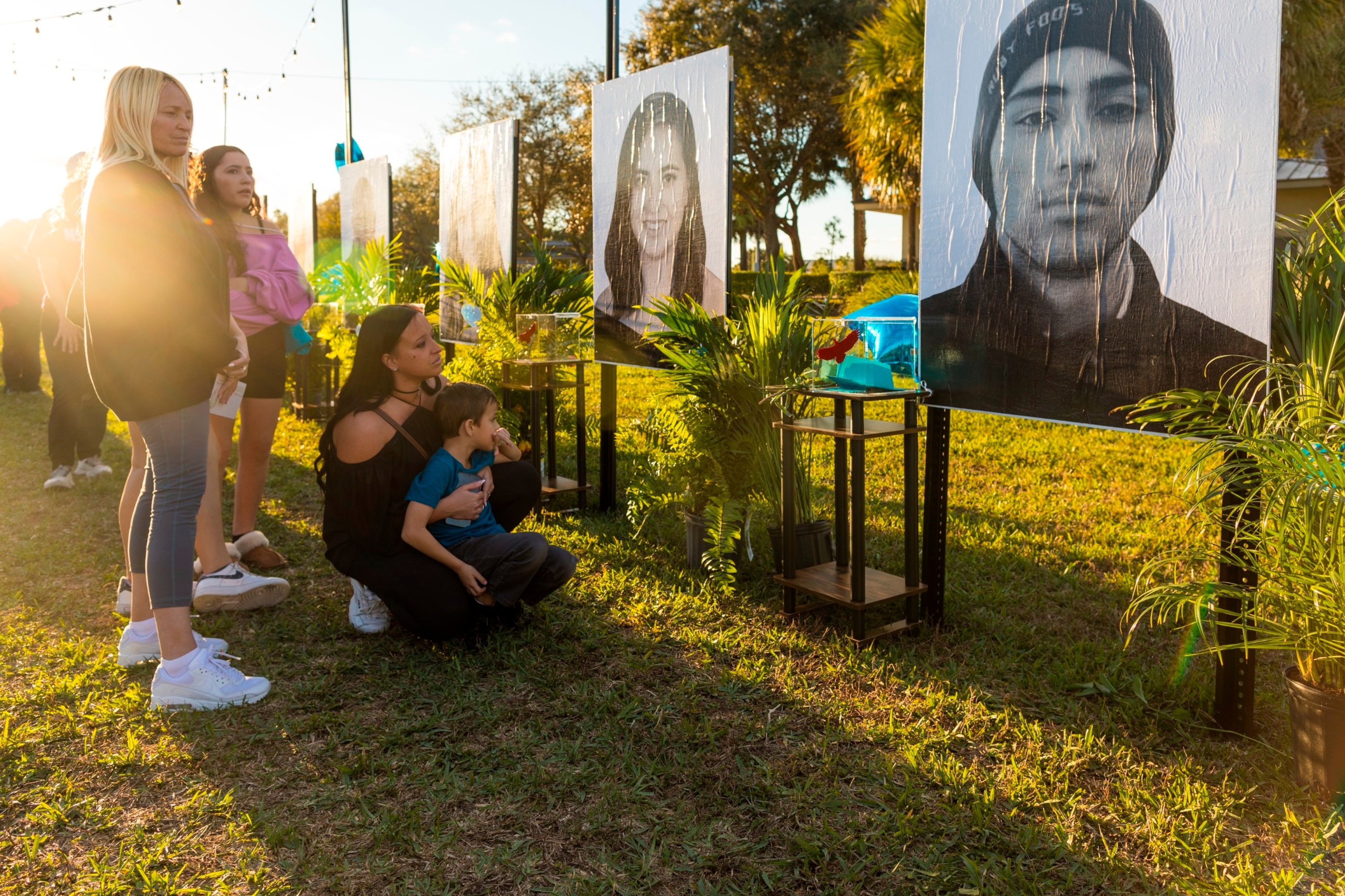 PHOTO: Mariana Rocha, holds her son Jackson as she observes a photo of her cousin Joaquin Oliver at a memorial on the fifth anniversary of the Marjory Stoneman Douglas High School mass shooting at Pine Trails Park, Feb. 14, 2023, in Parkland, Fla. 