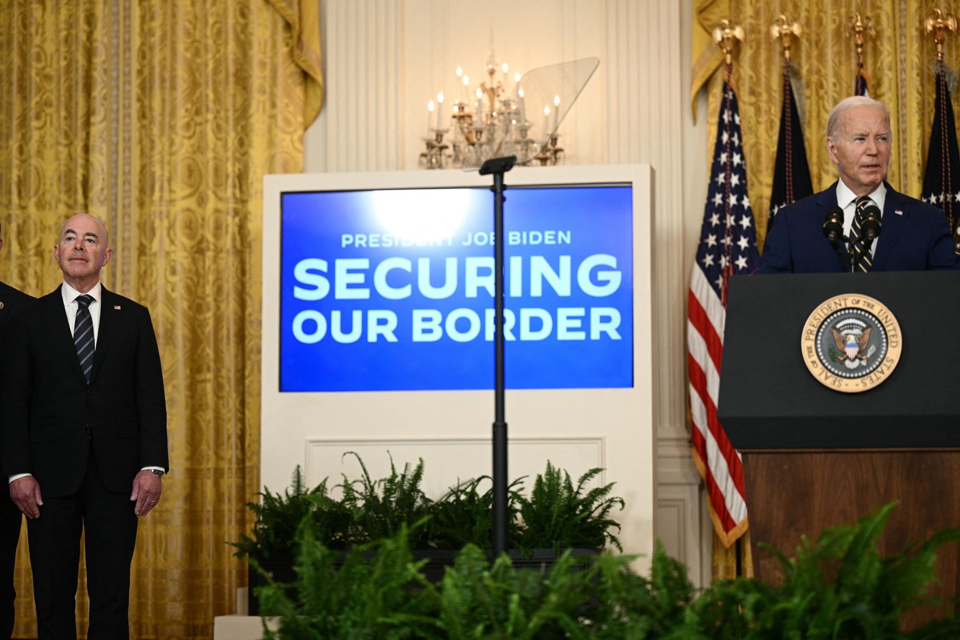 PHOTO: US Homeland Security Secretary Alejandro Mayorkas (L) listens to President Joe Biden speak in the East Room of the White House, in Washington, D.C., on June 4, 2024.