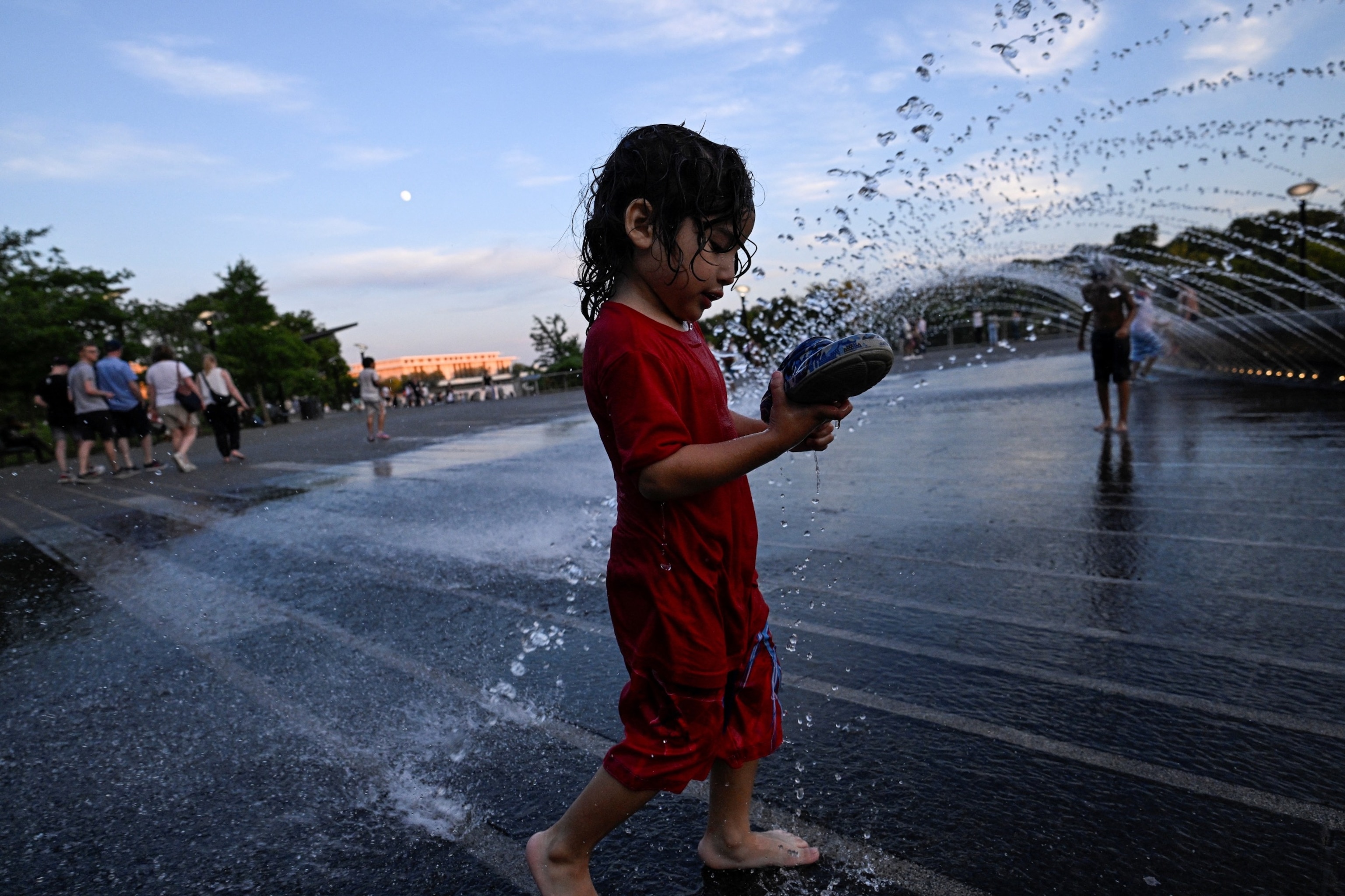 PHOTO: Mathew Calderon, 4, walks through a fountain at Georgetown Waterfront Park amid a heat wave in Washington, U.S., June 19, 2024.