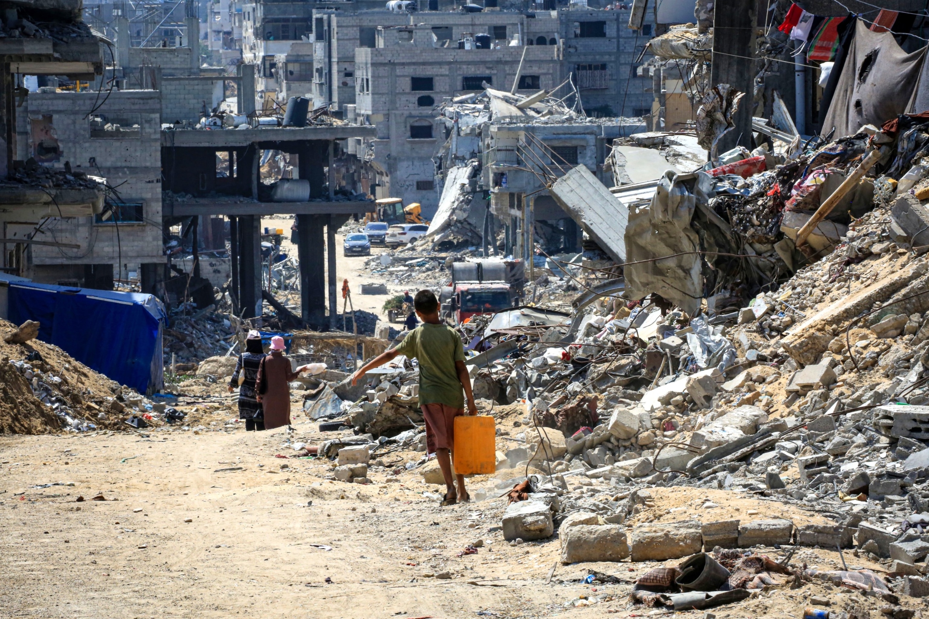 PHOTO: A youth carries water in Khan Yunis on the southern Gaza Strip, June 23, 2024.