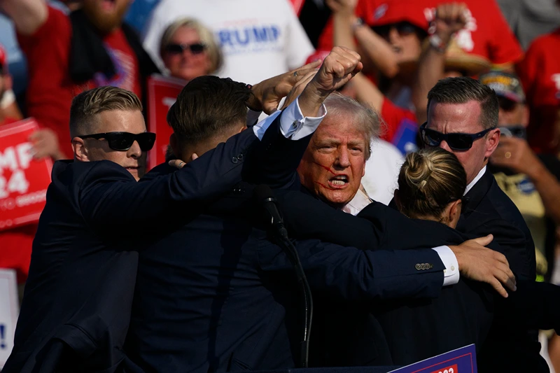 Donald Trump Holds A Campaign Rally In Butler, Pennsylvania
BUTLER, PENNSYLVANIA - JULY 13: Secret Service agents surround Republican presidential candidate former President Donald Trump onstage after he was injured at a rally on July 13, 2024 in Butler, Pennsylvania. According to Butler County District Attorney Richard Goldinger, the suspected gunman is dead after injuring former President Trump, killing one audience member and injuring at least one other. (Photo by Jeff Swensen/Getty Images)