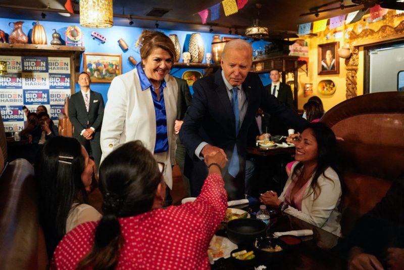 US President Joe Biden, alongside Maritza Rodriguez (in white), a campaign advisor for the Biden Nevada state team, greets people as he arrives at Lindo Michoacan restaurant ahead of a radio interview in Las Vegas, Nevada, on July 17, 2024. (Photo by Kent Nishimura / AFP) (Photo by KENT NISHIMURA/AFP via Getty Images)