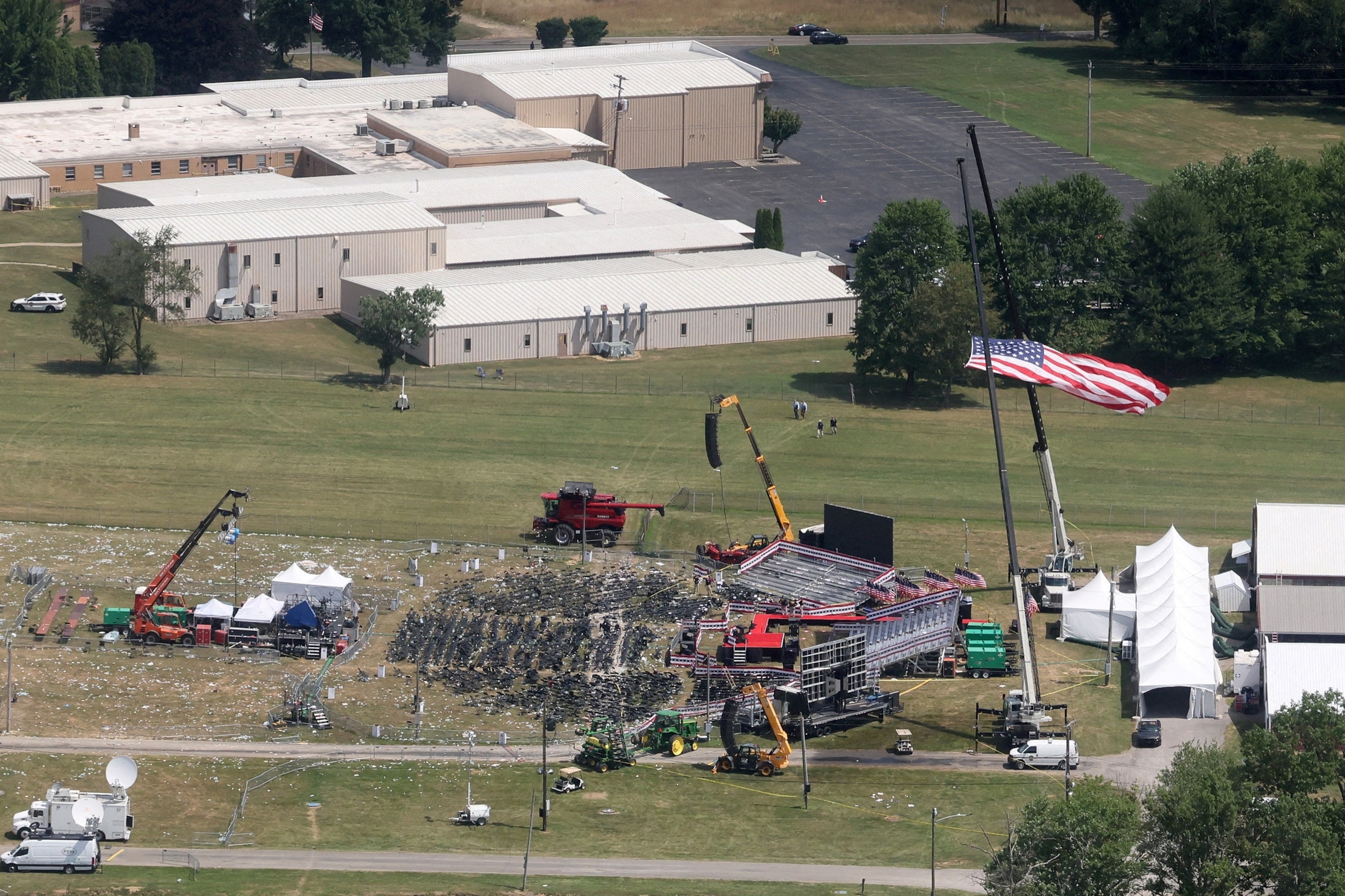 PHOTO: The stage where former President Donald Trump had been standing during an assassination attempt the day before, and the roof of a nearby building where a gunman was shot dead by law enforcement, in Butler, Pennsylvania, July 14, 2024. 