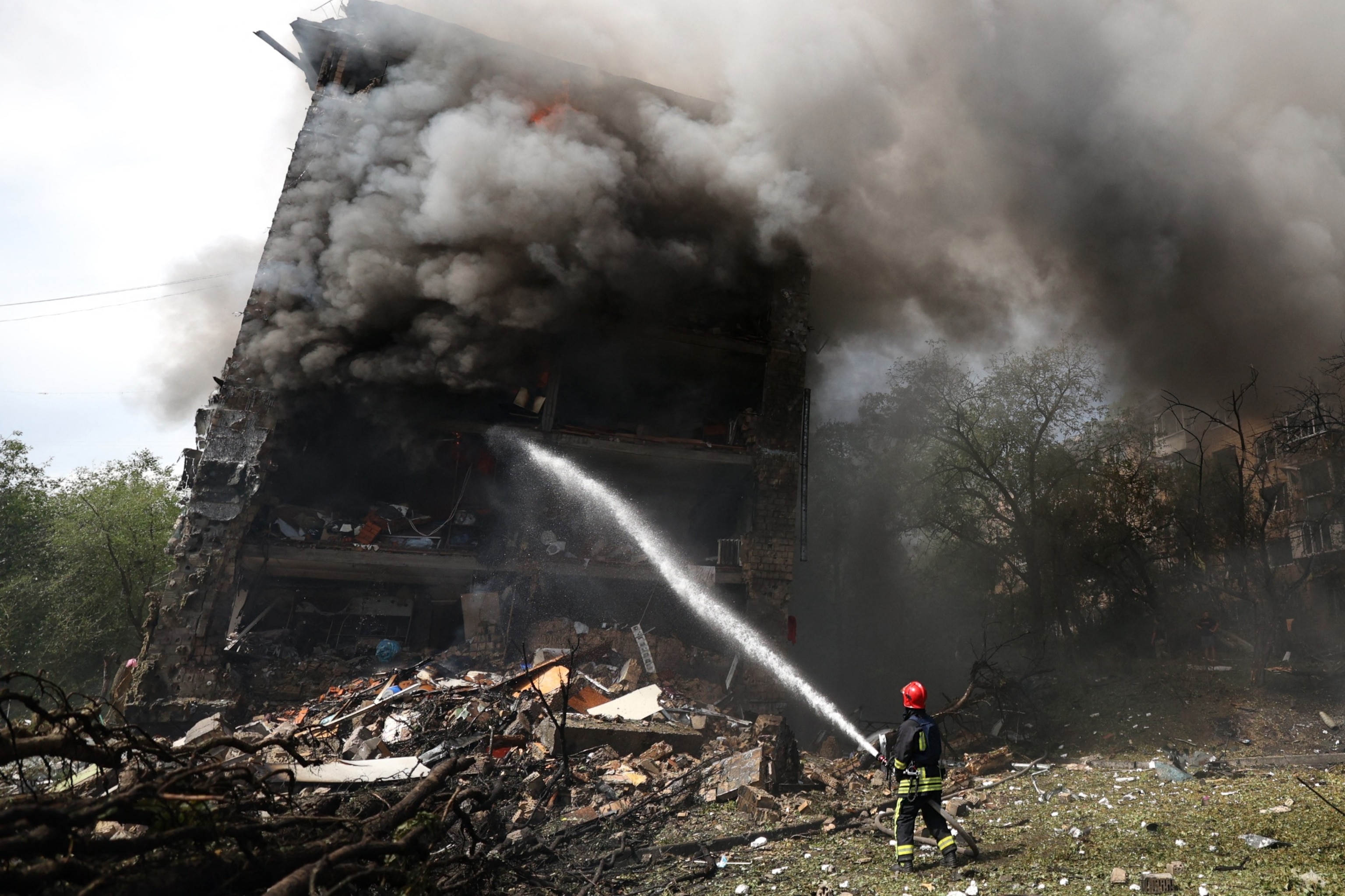 PHOTO: A Ukrainian firefighter works to extinguish a fire in a residential building following a missile attack in Kyiv on July 8, 2024.