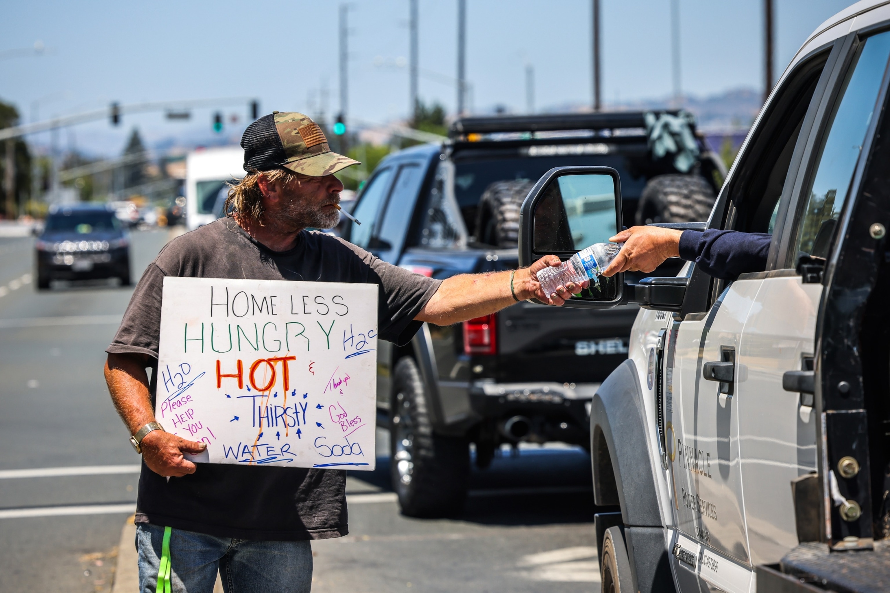 PHOTO: Ken Gergits, 53, panhandles for water in the blazing sun as temperatures reached 100 degrees in Santa Rosa, Calif., on July 3, 2024. 