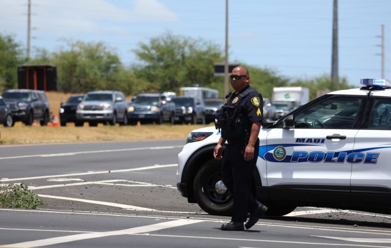 WAILUKU, HAWAII - AUGUST 11: A Maui police officer monitors traffic on the Honoapiilani highway as cars back up for miles before residents are allowed back into areas affected by the recent wildfire on August 11, 2023 in Wailuku, Hawaii. Dozens of people were killed and thousands were displaced after a wind-driven wildfire devastated the town of Lahaina on Tuesday. Crews are continuing to search for missing people. (Photo by Justin Sullivan/Getty Images)