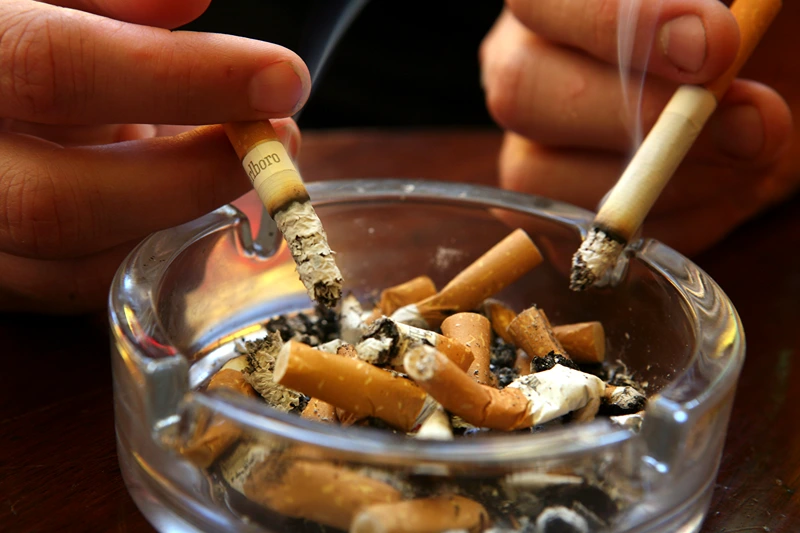 A couple smoke cigarettes in a public house in Bath, on June 30 2007 in Somerset, England. From 6am July 1 smoking in all enclosed places such as cafes and pubs will be banned. (Photo by Matt Cardy/Getty Images)