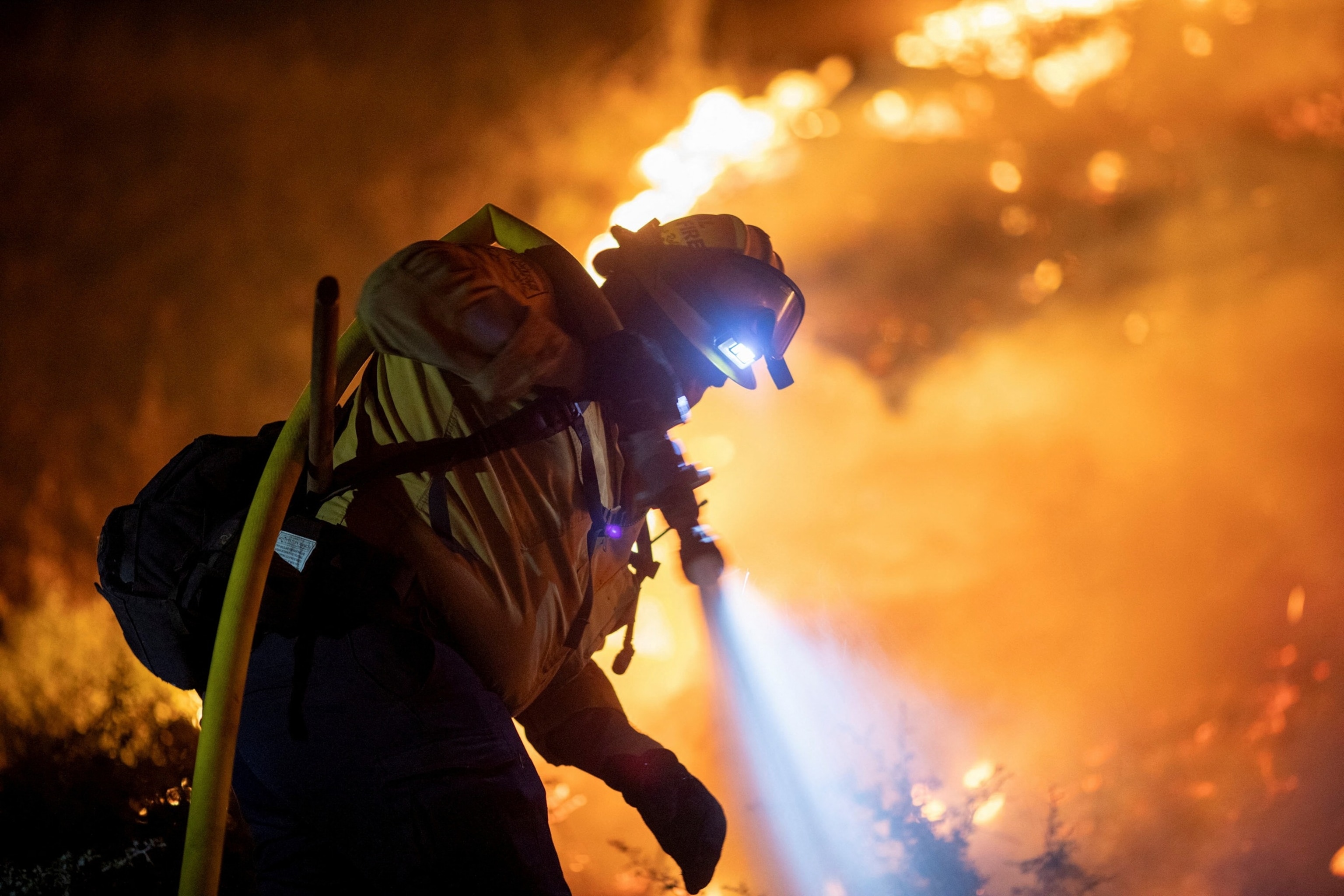 A Cal Fire firefighter tackles the Bridge Fire threatening mountain communities to the northeast of Los Angeles, in Wrightwood, California, U.S. September 11, 2024. REUTERS/Ringo Chiu