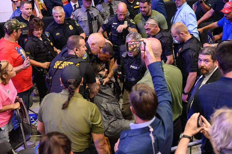 A man is apprehended by security and police after jumping onto the media platform at a campaign rally for Republican presidential nominee, former U.S. President Donald Trump at the 1st Summit Arena on August 30, 2024 in Johnstown, Pennsylvania. Promising to cut energy bills in half, conduct the largest deportation operation in history and put a 200% tariff on foreign made automobiles, Trump rallied his supporters in the all-important battleground state of Pennsylvania. (Photo by Justin Merriman/Getty Images)