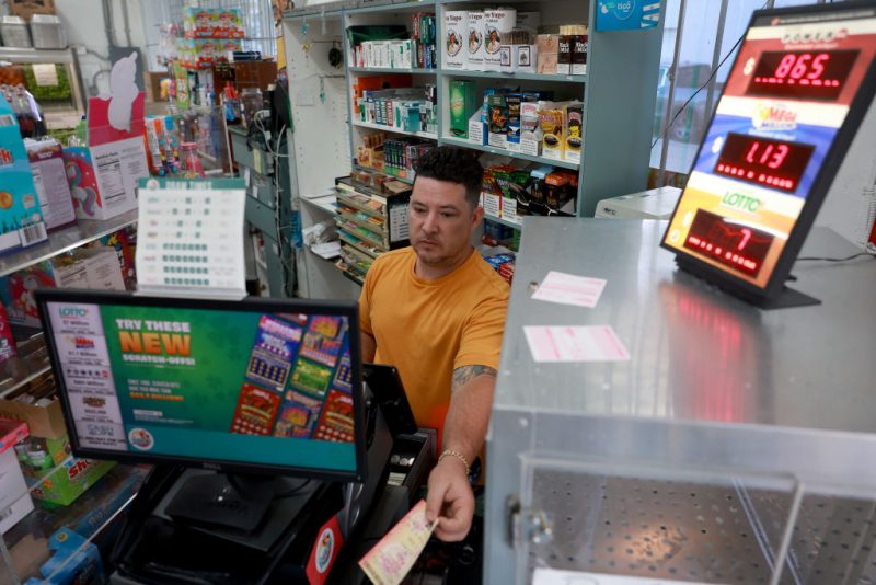 MIAMI, FLORIDA - MARCH 26: Karl Lopez prints out a Mega Million lottery ticket for a customer at the La Esquina Tropical supermarket on March 26, 2024 in Miami, Florida. The Mega Millions jackpot has reached $1.13 billion for tonight's drawing. (Photo Joe Raedle/Getty Images)