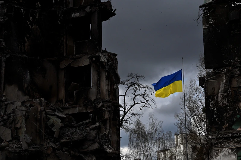 TOPSHOT - The Ukrainian flag flutters between buildings destroyed in bombardment, in the Ukrainian town of Borodianka, in the Kyiv region on April 17, 2022. - Russia invaded Ukraine on February 24, 2022. (Photo by Sergei SUPINSKY / AFP) (Photo by SERGEI SUPINSKY/AFP via Getty Images)