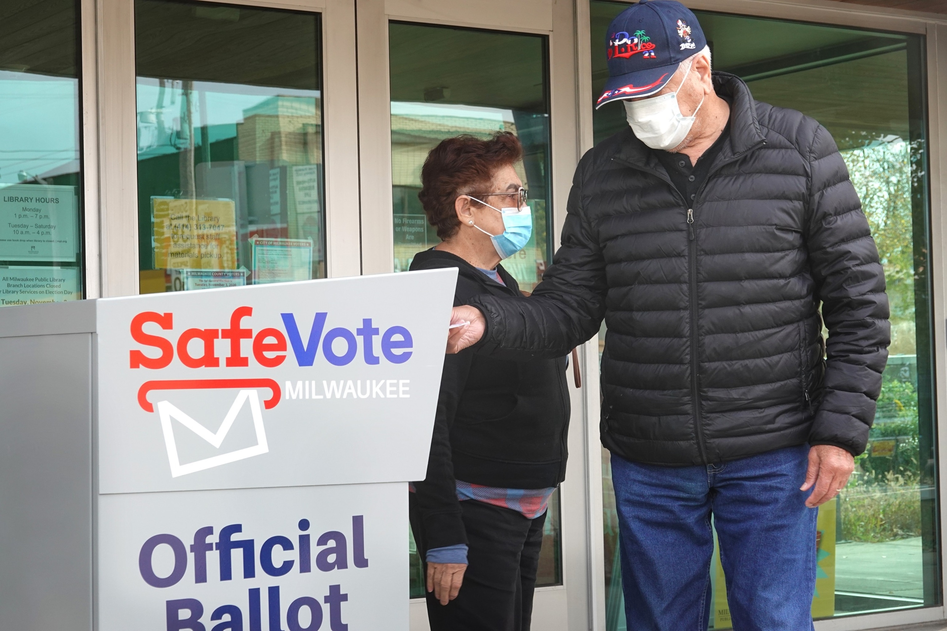 PHOTO: In this Oct. 20, 2020 file photo, residents drop mail-in ballots in an official ballot box outside of the Tippecanoe branch library on in Milwaukee.