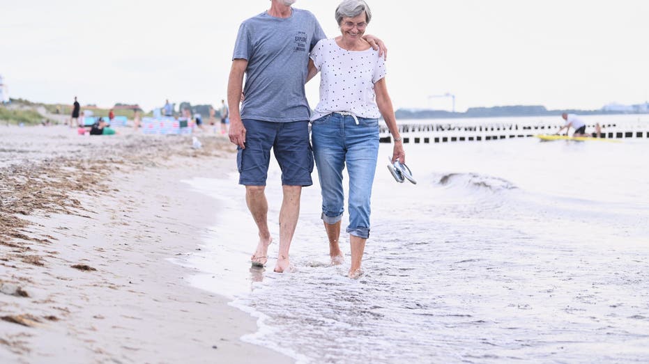 couple walking barefoot on beach