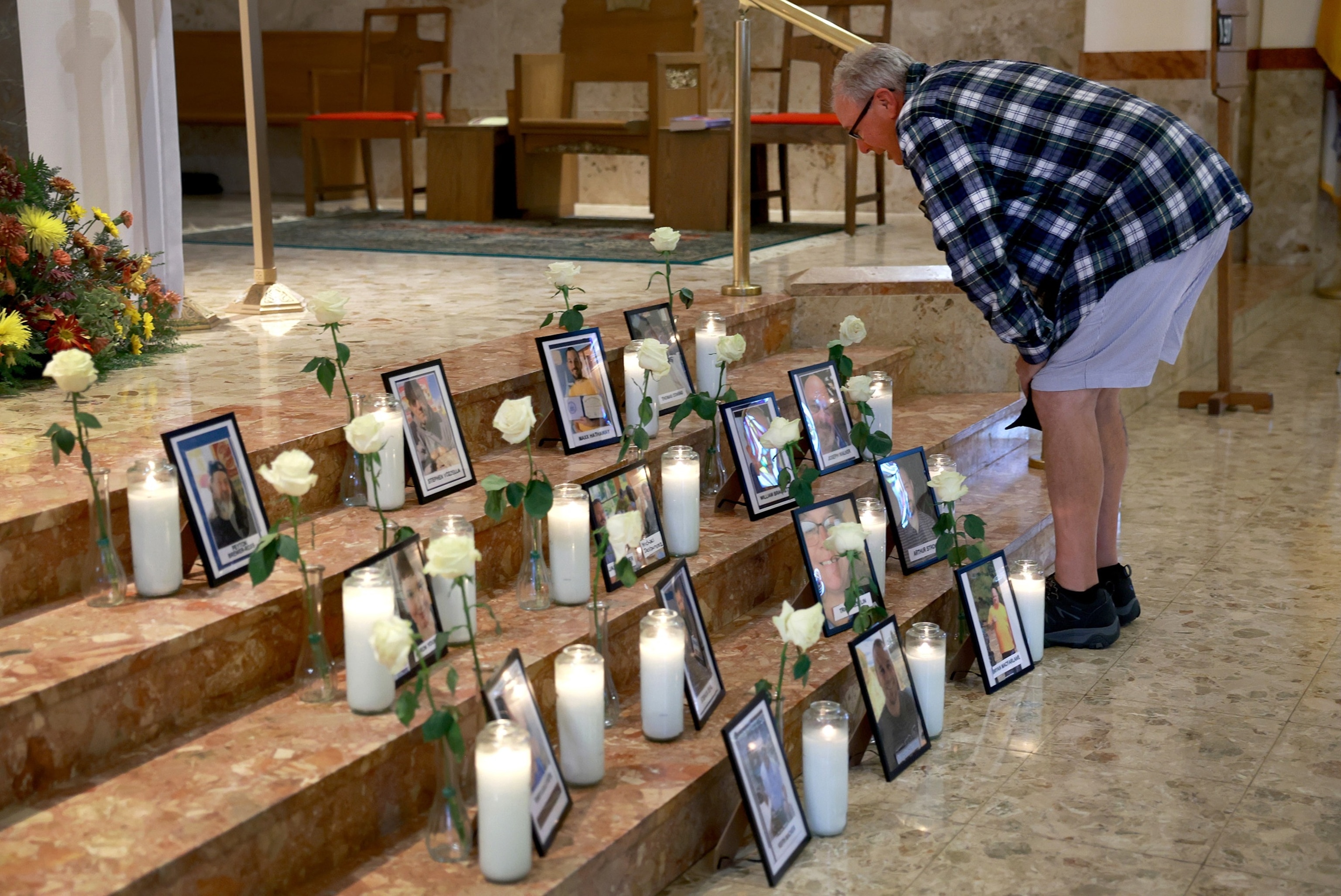 PHOTO: in this Oct. 29, 2023, file photo, Tim Conrad looks on at a picture of his son, Thomas Conrad, during a memorial at the Holy Family Church for those whom a mass shooter killed in Lewiston, Maine.