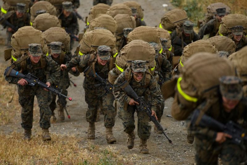 Female United States Marine Corps (USMC) recruits from Lima Company, the first gender integrated training class in San Diego complete their 9.7 mile hike on Edson Range to the top of a mountain called The Reaper, during The Crucible, the final part of phase three of recruit training before officially becoming US Marines on April 22, 2021 at Camp Pendleton in San Diego County, California. - Lima Company is the first gender integrated company with a female platoon training alongside male platoons at the west coast Marine Corps Recruit Depot, San Diego (MCRDSD). The Crucible is the final 54-hour test for the recruits, where upon completion the recruits will receive their eagle, globe, and anchor pin to officially become US Marines. Recruits had to spend two weeks in quarantine before beginning training due to the Covid-19 pandemic. Congress ordered the Marine Corps to fully integrate women into its west coast training battalions by 2028 under the National Defense Authorization Act. Women make up about 9 percent of the Marine Corps. (Photo by Patrick T. FALLON / AFP) (Photo by PATRICK T. FALLON/AFP via Getty Images)