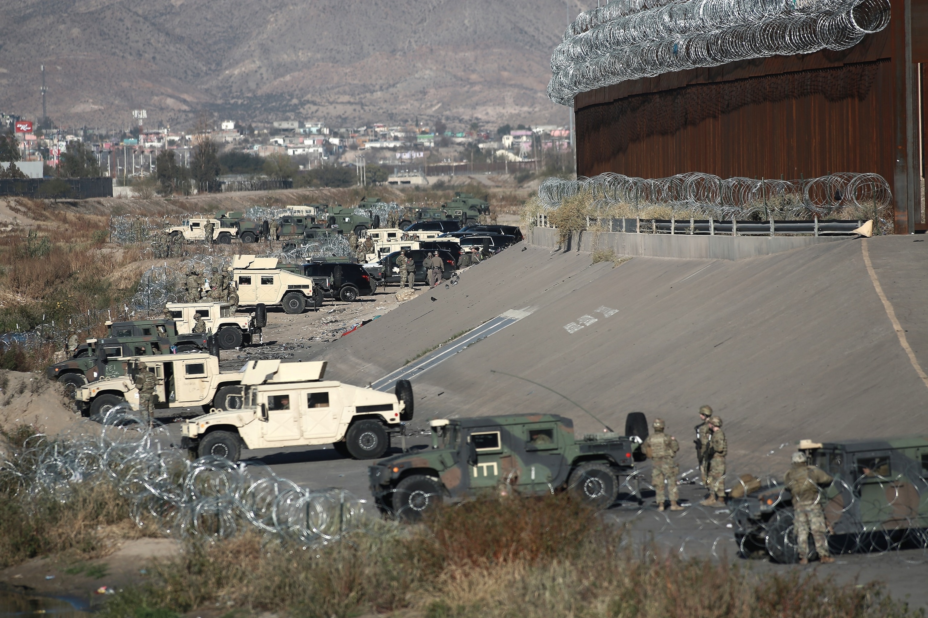 PHOTO: In this Dec. 20, 2022, file photo, National Guard troops and state troopers line the bank of the border on American side in Ciudad Juarez, Mexico.