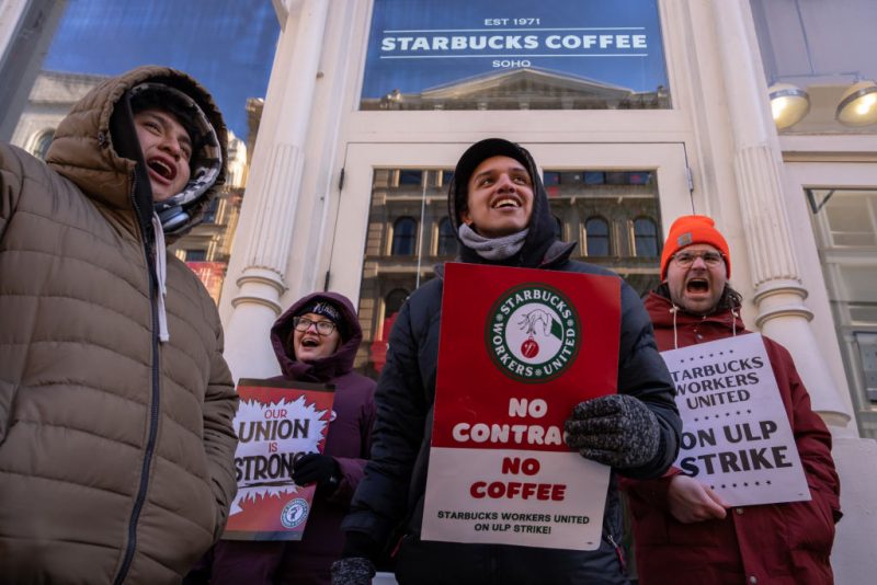 NEW YORK, NEW YORK - DECEMBER 23: Starbucks employees, union members and supporters strike outside of a Starbuck store which is closed down due to the strike on December 23, 2024 in New York City. Starbucks Workers United stated that union workers in Missouri, New Jersey, and New York started their strike on Sunday, following the participation of locations in Colorado, Ohio, and Pennsylvania on Saturday. The union represents over 10,000 employees across more than 525 stores. (Photo by Adam Gray/Getty Images)