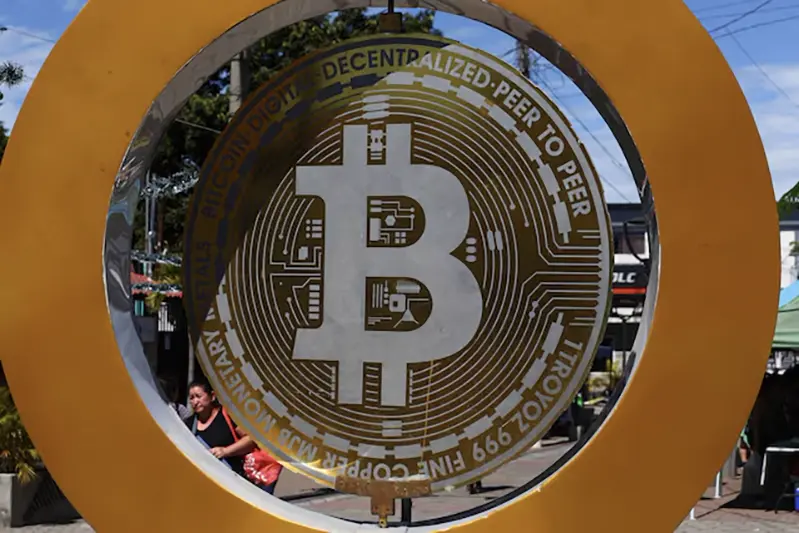 A woman passes by the Bitcoin Monument after bitcoin soared above $100,000, in Ilopango, El Salvador, December 5, 2024. REUTERS/Jose Cabezas/File Photo