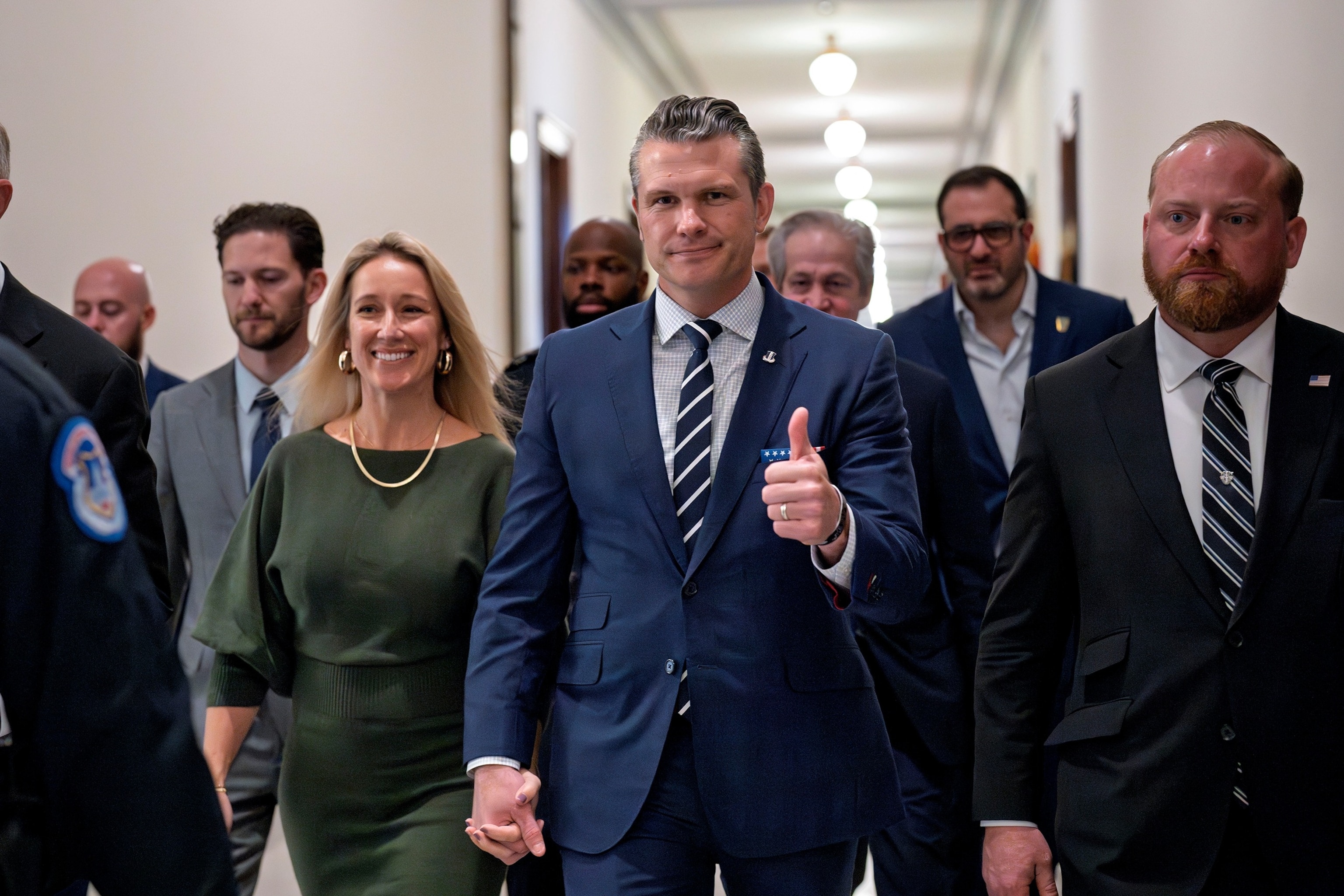 PHOTO:Pete Hegseth gives a thumbs-up as he walks with his wife Jennifer Rauchet to meet with Sen. Joni Ernst, a member of the Senate Armed Services Committee, at the Capitol in Washington, D.C., Dec. 9, 2024.