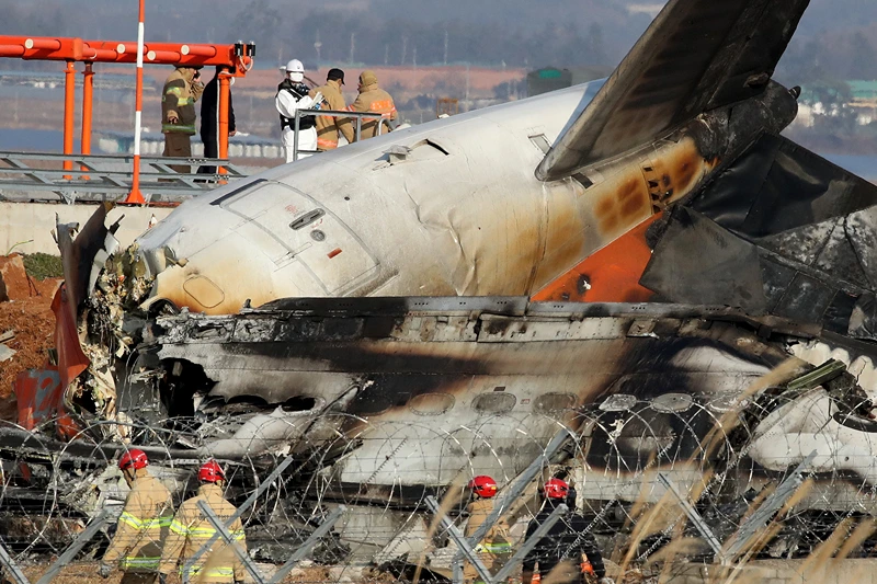 Firefighters and rescue teams work at the wreckage of a passenger plane at Muan International Airport on December 29, 2024 in Muan-gun, South Korea. A plane carrying 181 people, Jeju Air Flight 7C2216, crashed at Muan International Airport in South Korea after skidding off the runway and colliding with a wall, resulting in an explosion. Latest reports said that at least 179 people had died. (Photo by Chung Sung-Jun/Getty Images)