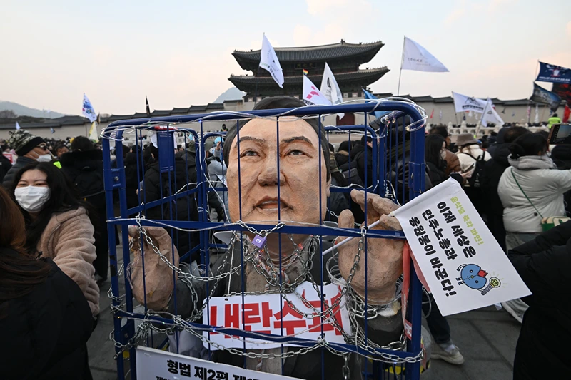 An effigy of South Korea's impeached President Yoon Suk Yeol is seen in a mock prison as protesters take part in a rally calling for Yoon's ouster in front of the Gwanghwamun Gate of Gyeongbokgung Palace in Seoul on December 21, 2024. (Photo by Jung Yeon-je / AFP) (Photo by JUNG YEON-JE/AFP via Getty Images)