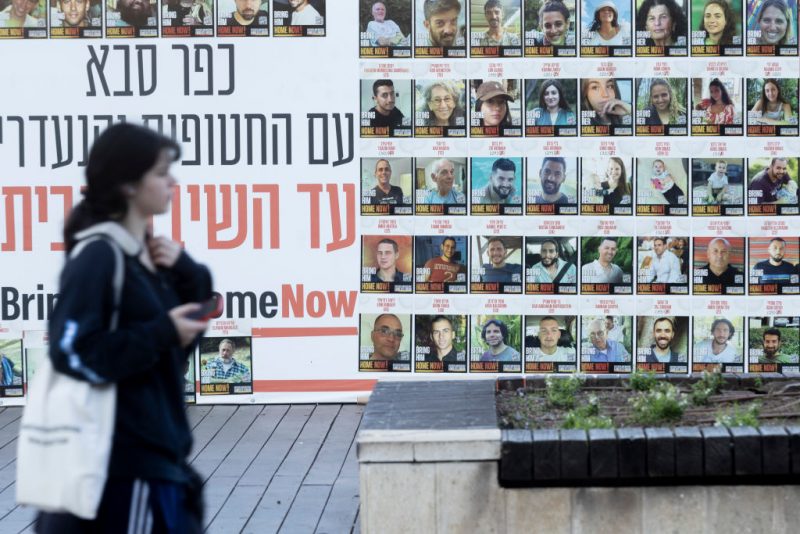 KFAR SABA, ISRAEL - JANUARY 6: A woman passes by a wall covered with photos of hostages that were kidnaped to the Gaza Strip during Hamas deadly attack on January 6, 2025 in Kfar Saba, Israel. Israel and Hamas resumed indirect ceasefire talks through mediators in Qatar, as Israel continued airstrikes in Gaza over the weekend. (Photo by Amir Levy/Getty Images)