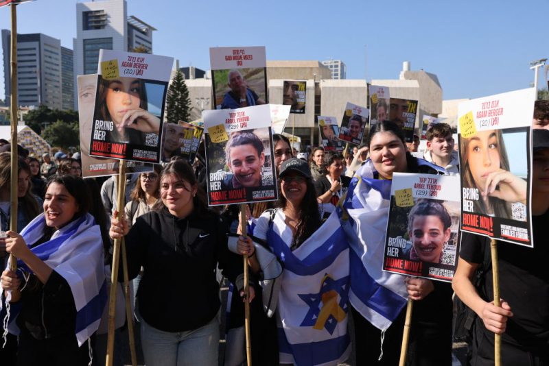 Demonstrators raise placards as they celebrate the release of three hostages held captive in Gaza since the October 7, 2023 attack by Palestinian militants, in Tel Aviv on January 30, 2025. Israel and Hamas were set to carry out their third hostage-prisoner exchange on January 30, with three Israelis and five Thai captives slated for release as part of a ceasefire deal aimed at ending the Gaza war. (Photo by Menahem KAHANA / AFP) (Photo by MENAHEM KAHANA/AFP via Getty Images)