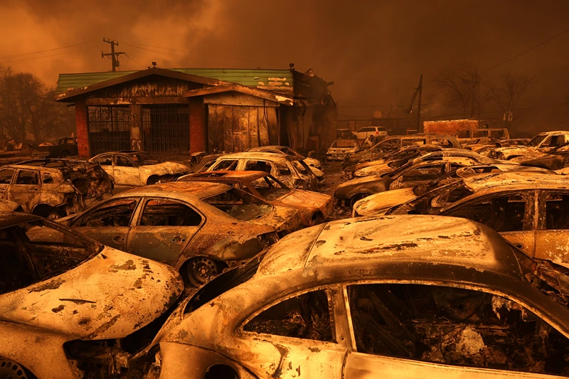 ALTADENA, CALIFORNIA - JANUARY 08: Cars destroyed by the Eaton Fire sit in the parking area of a burned auto shop on January 08, 2025 in Altadena, California. Multiple wildfires fueled by intense Santa Ana Winds are burning across Los Angeles County. Two people have been killed, over 25,000 acres have burned, and 30,000 people have been evacuated. (Photo by Justin Sullivan/Getty Images)