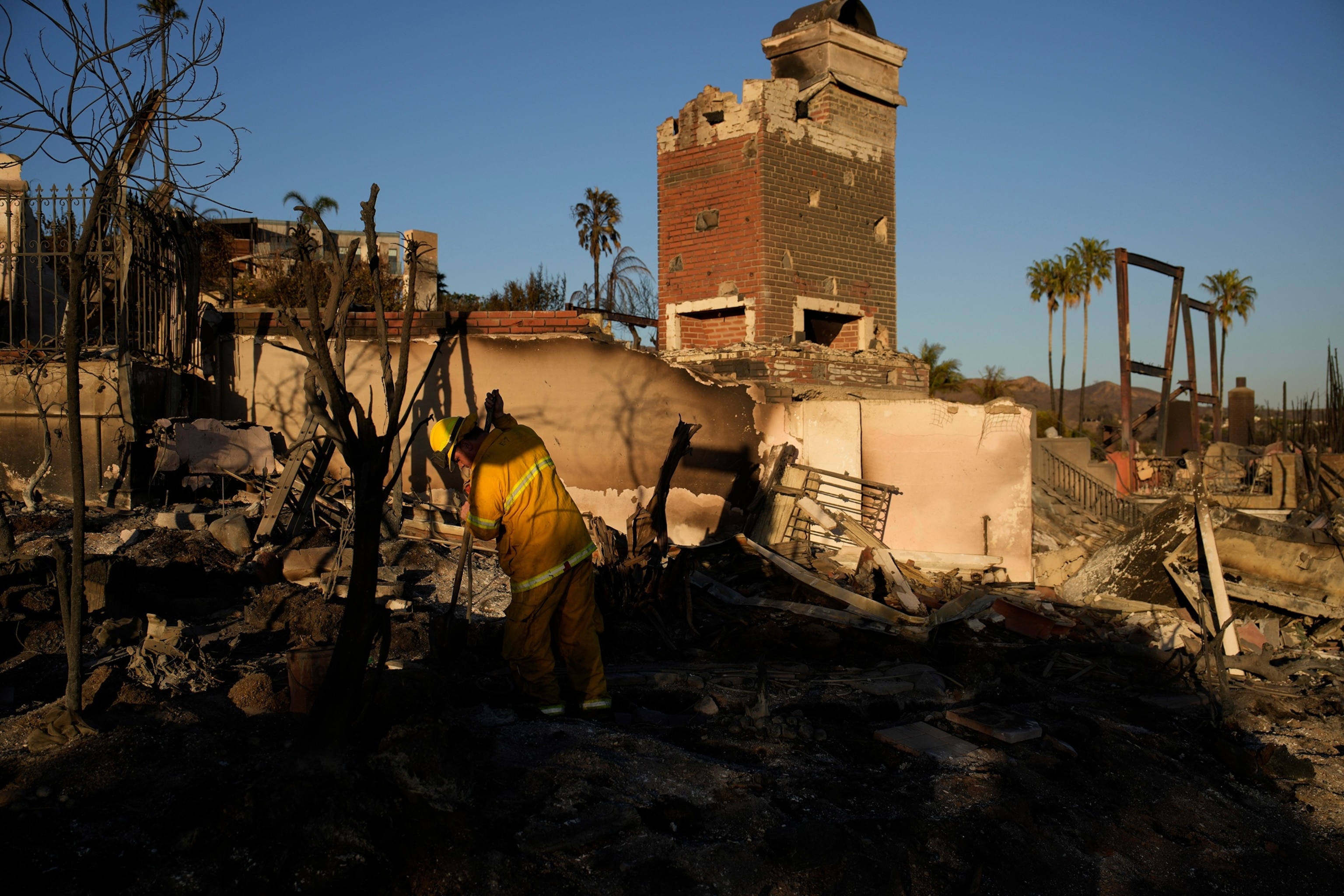 PHOTO: Trevor Pratt, a firefighter with the City of San Francisco, looks for hot spots at homes burned by the Palisades Fire, Jan. 13, 2025, in Pacific Palisades, Calif. 