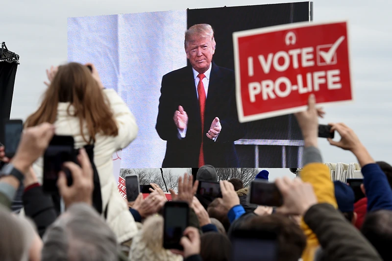 TOPSHOT - Pro-life demonstrators listen to US President Donald Trump as he speaks at the 47th annual "March for Life" in Washington, DC, on January 24, 2020. - Trump is the first US president to address in person the country's biggest annual gathering of anti-abortion campaigners. (Photo by OLIVIER DOULIERY / AFP) (Photo by OLIVIER DOULIERY/AFP via Getty Images)