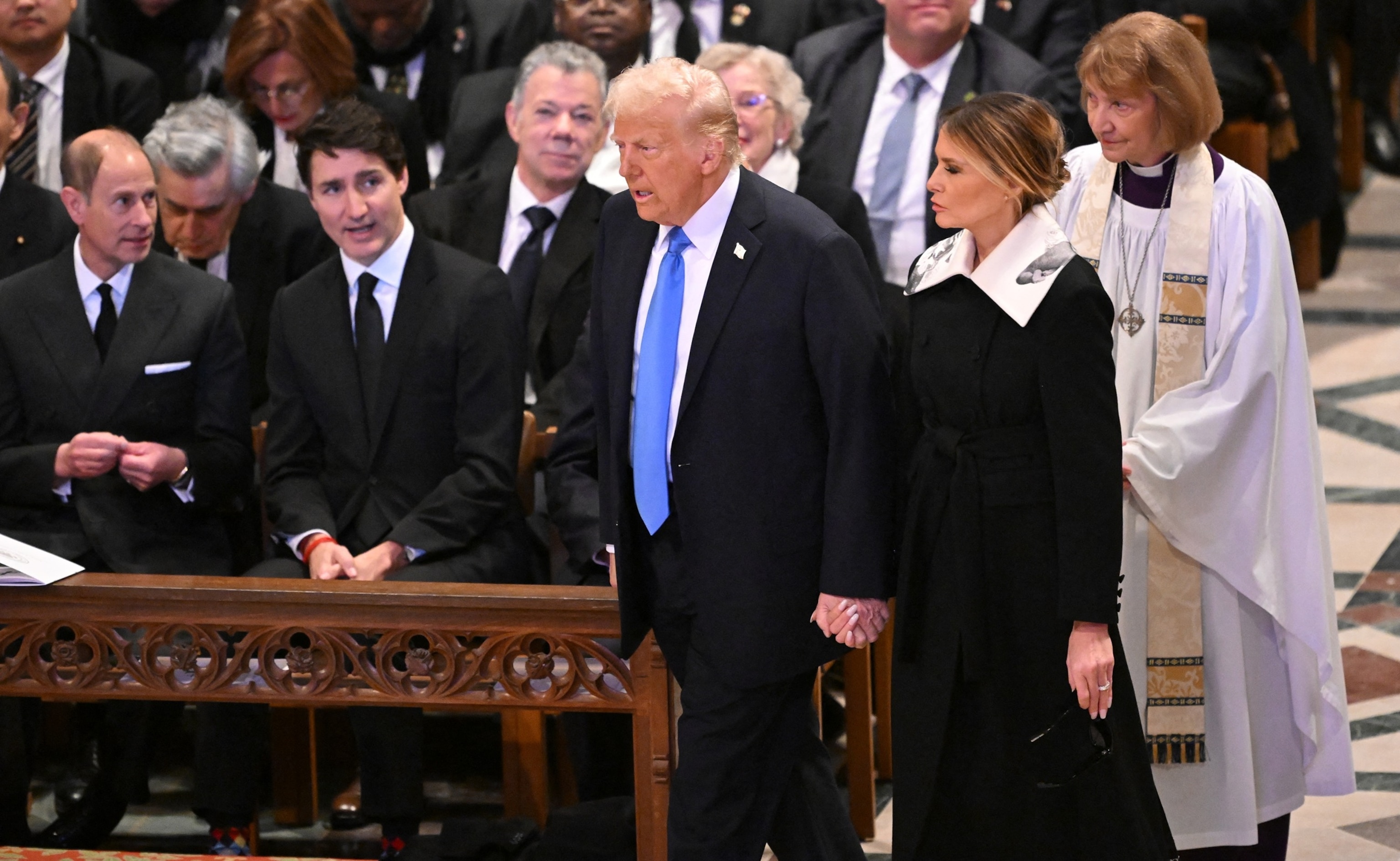 PHOTO: President-elect Donald Trump and former First Lady Melania Trump walk past Canadian Prime Minister Justine Trudeau as they arrive to attend the State Funeral Service for former President Jimmy Carter, January 9, 2025. 