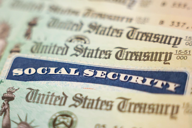 In this photo illustration, a Social Security card sits alongside checks from the U.S. Treasury on October 14, 2021 in Washington, DC. The Social Security Administration announced recipients will receive an annual cost of living adjustment of 5.9%, the largest increase since 1982. The larger increase is aimed at helping to offset rising inflation. (Photo illustration by Kevin Dietsch/Getty Images)